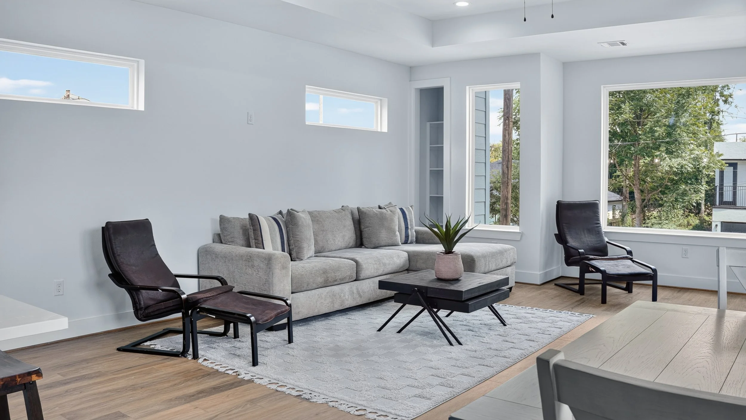 Living and dining area with wood look flooring, a blue console table, and a gray sofa