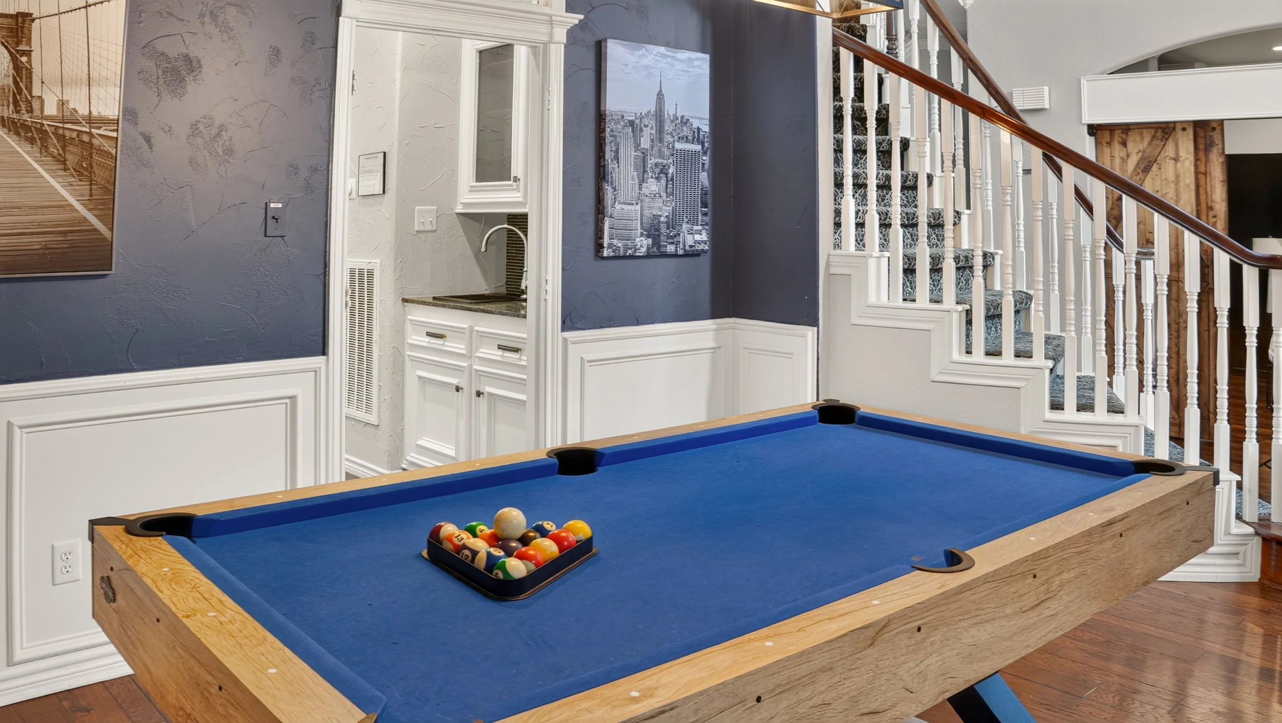 Game room with a blue felt pool table and dark accent walls