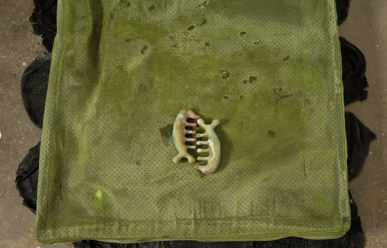 A hair claw clip on a green, textured fabric surface.