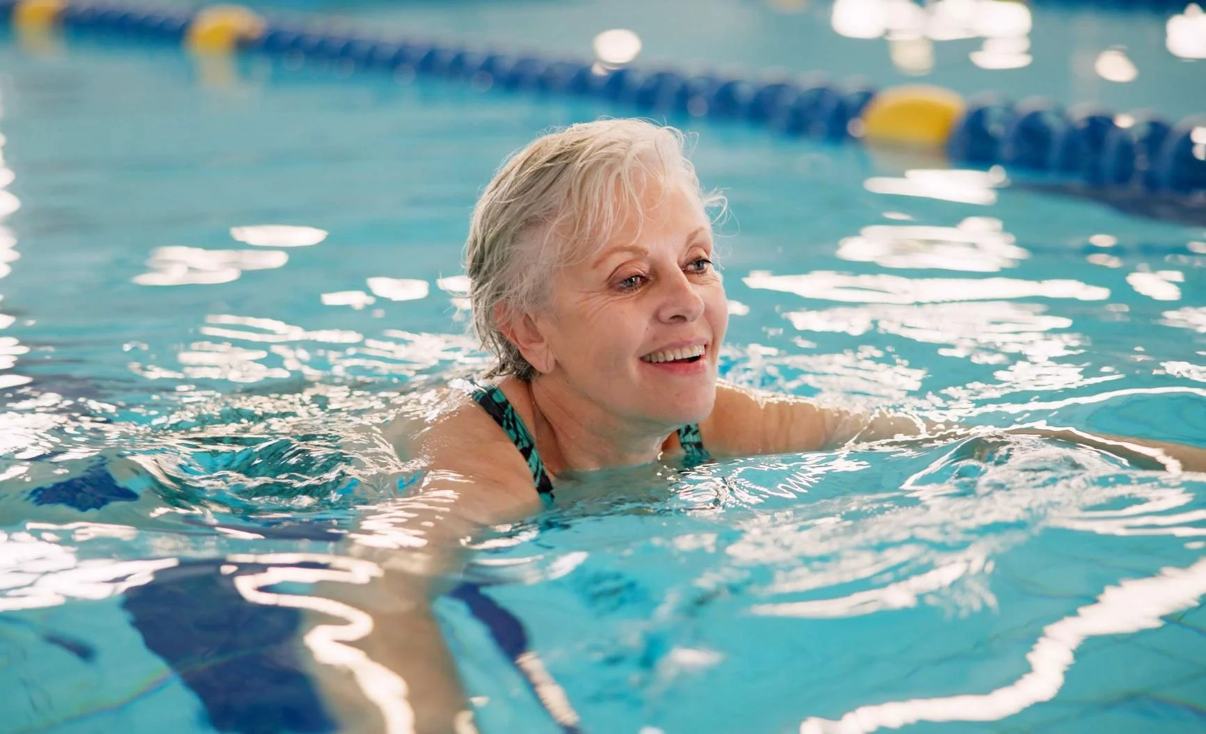 Adult swimming at school of little swimmers