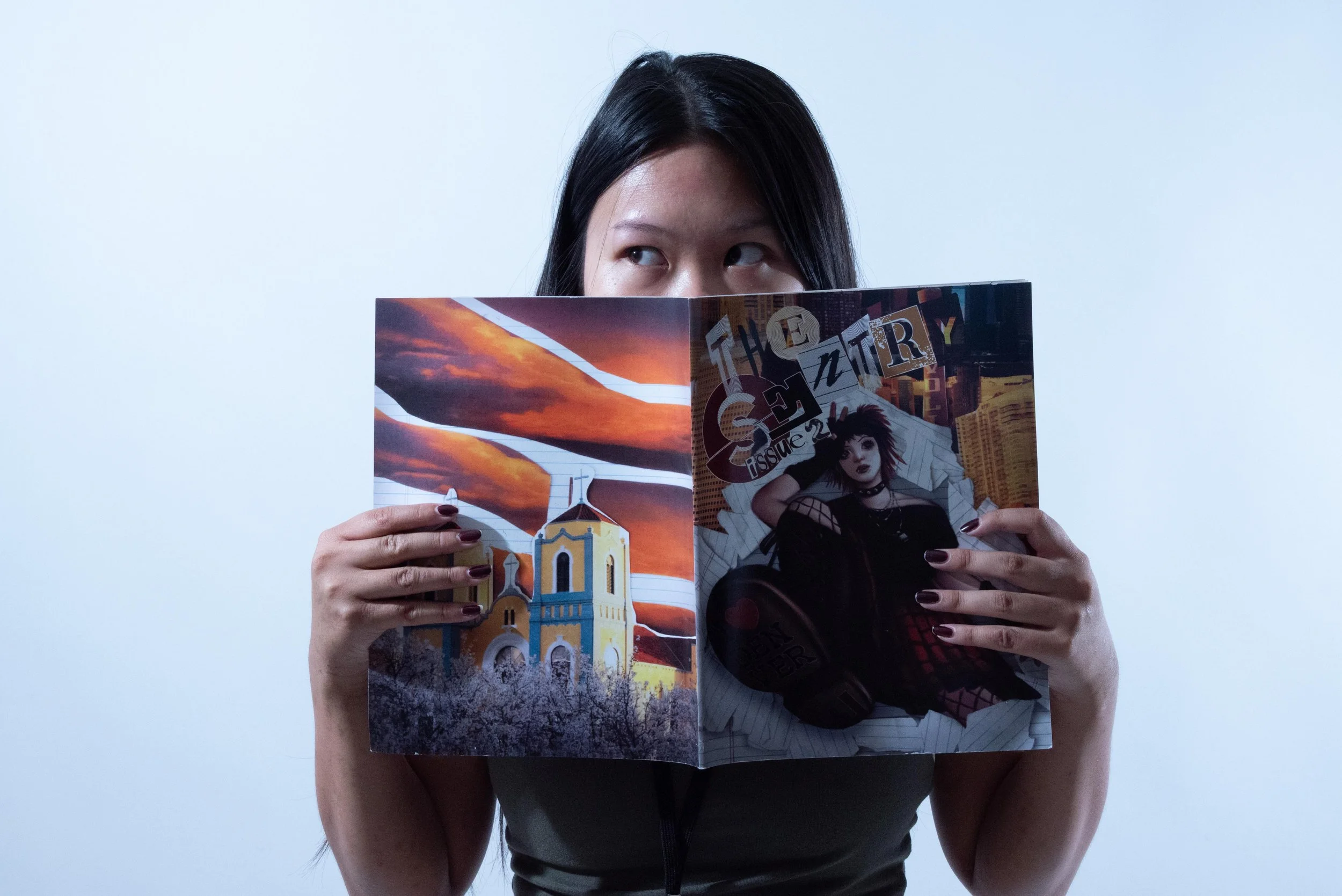 Woman with dark hair reading a colorful magazine against a plain white background.