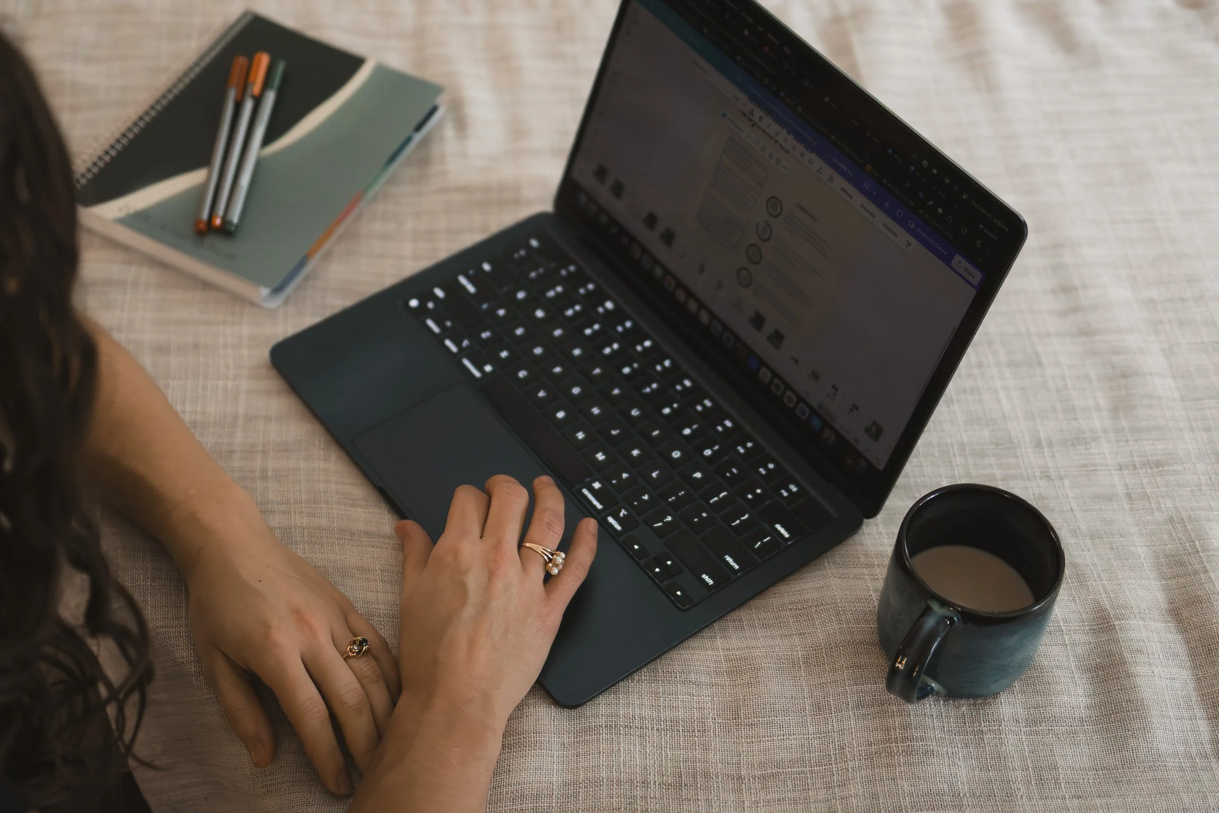 woman working at laptop with mug of tea
