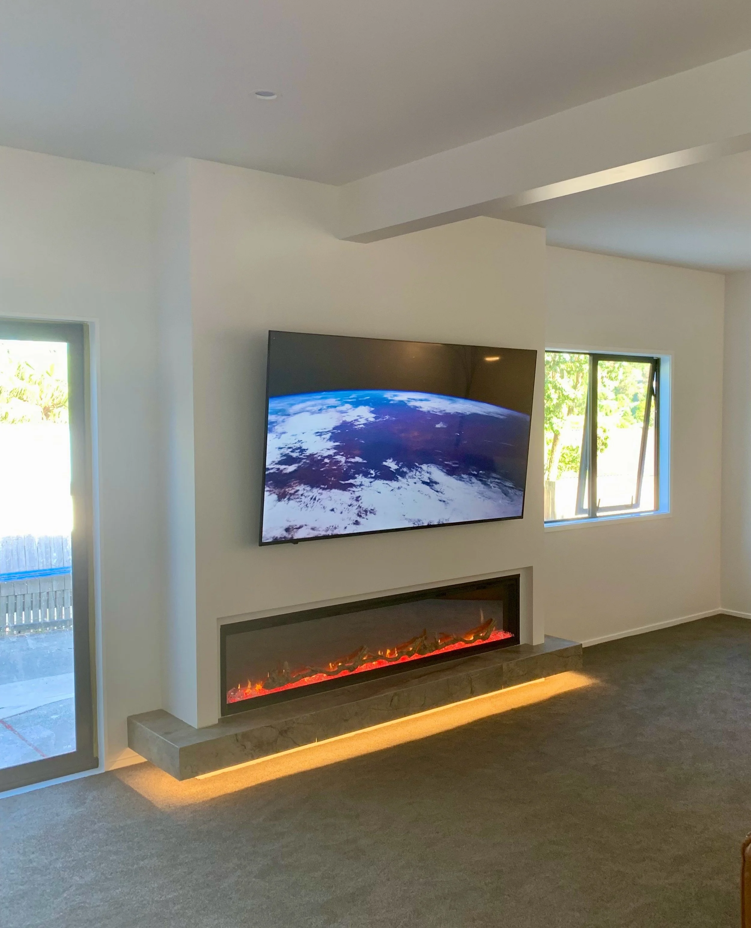 We did this renovation a few years ago in Torbay. 
We opened up our clients living room using big steel beams incorporating their unused storage room into the lounge and making a feature TV wall with built In fireplace. 
It was a really fun project. 
