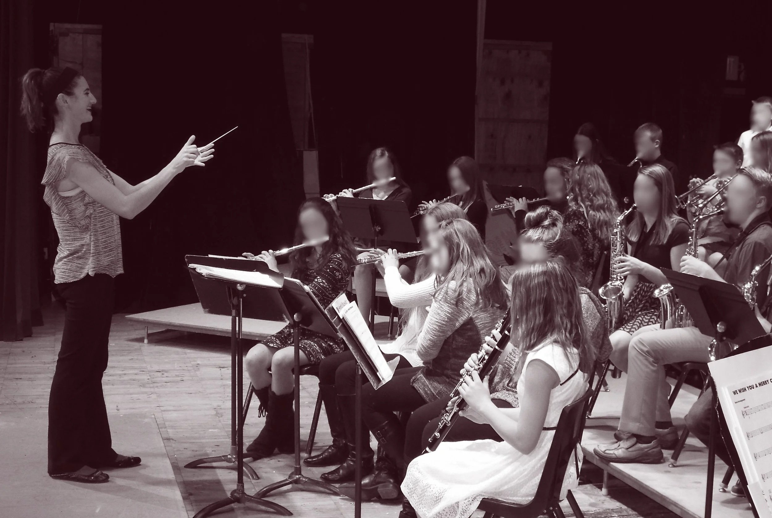 Photo of woman conducting a band of young students