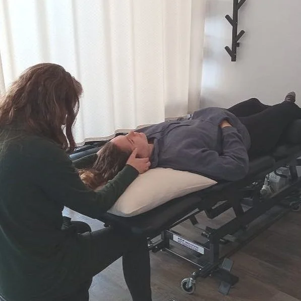 Nikki holding Jessica's head in her hands during a treatment in the clinic.