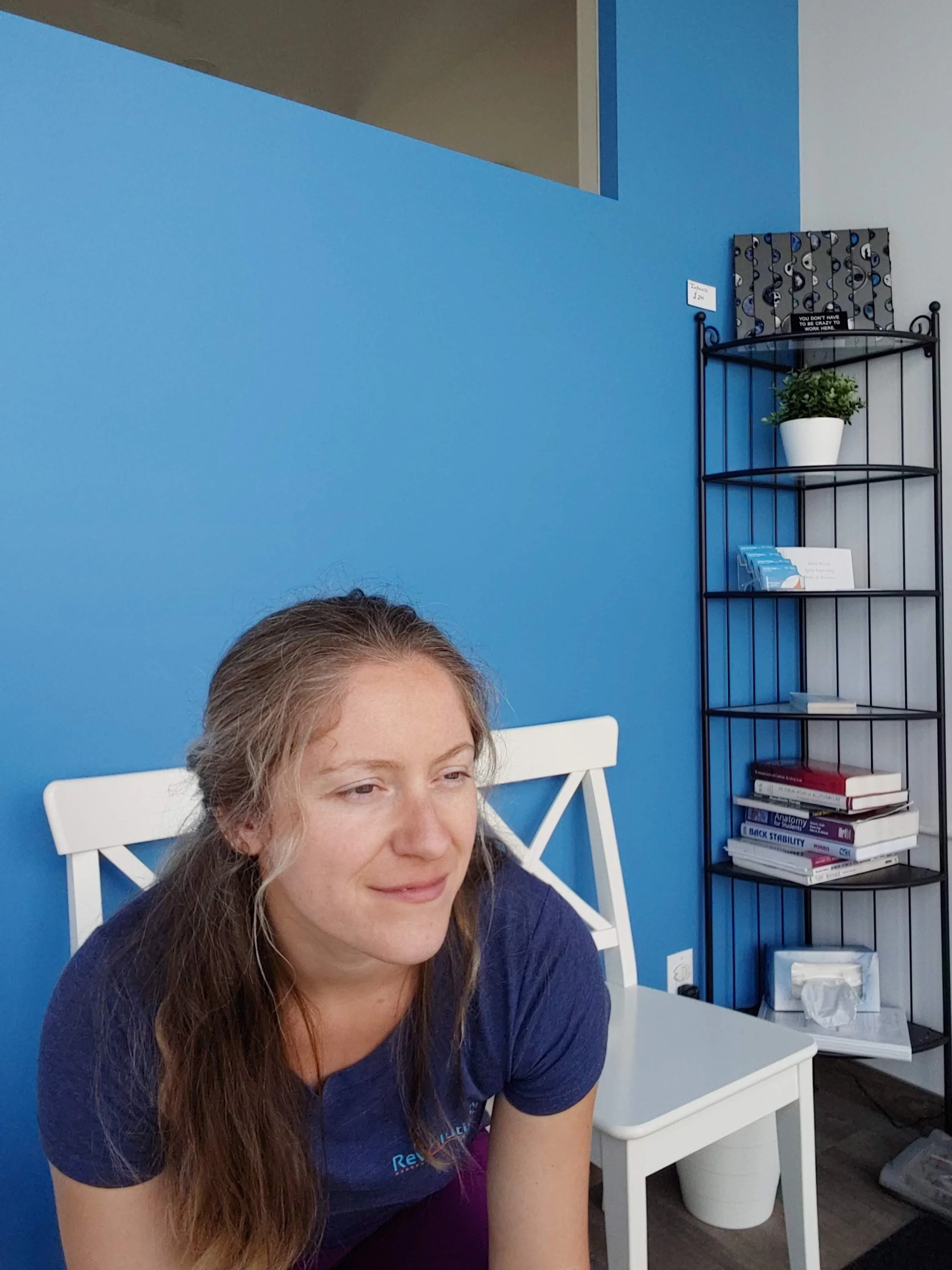 Owner and Athletic Therapist, Nikki Smith, sitting in the waiting area at Revolution.