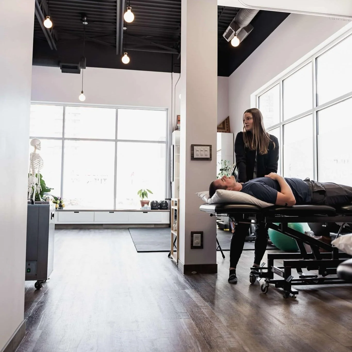 Certified Athletic Therapist treating in the open air clinic space at Revolution Rehab. Photo credit Louise Anderson Photography.