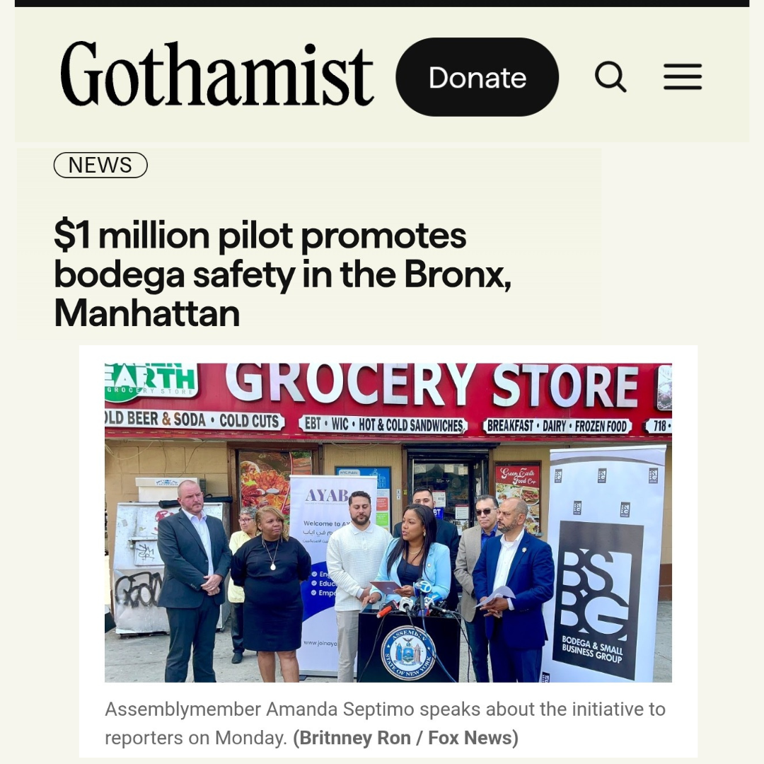 A group of people standing outside a grocery store, with some speaking at a press conference in front of a microphone. The store has a large red sign that says 'GROCERY STORE' and a banner displaying various food items. The people are dressed in form