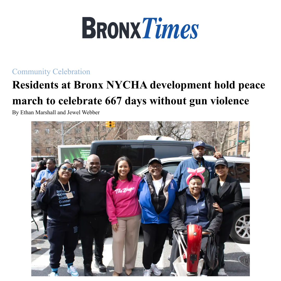 Group of people standing outdoors in front of vehicles, celebrating peace march with smiles and peace symbols.
