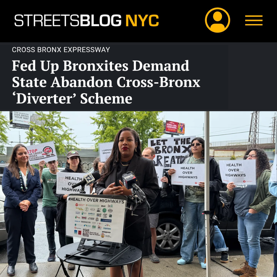A woman speaking at a press conference surrounded by protesters holding signs that say 'Health Over Highways.'