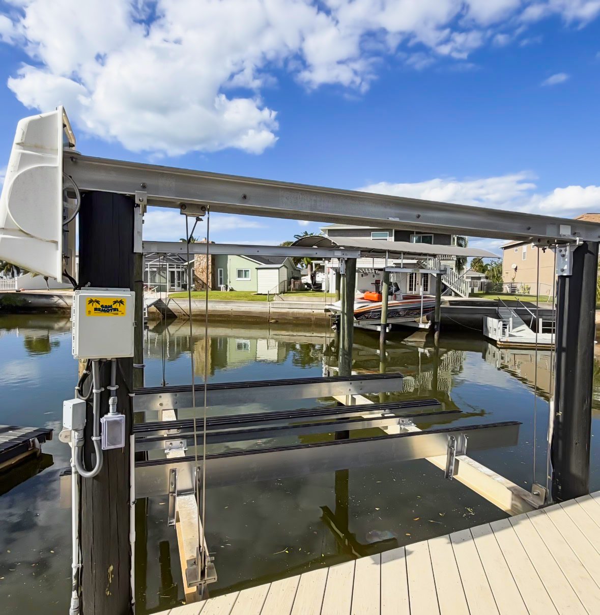 A close-up view of the bow of a black boat docked at a marina on the water.