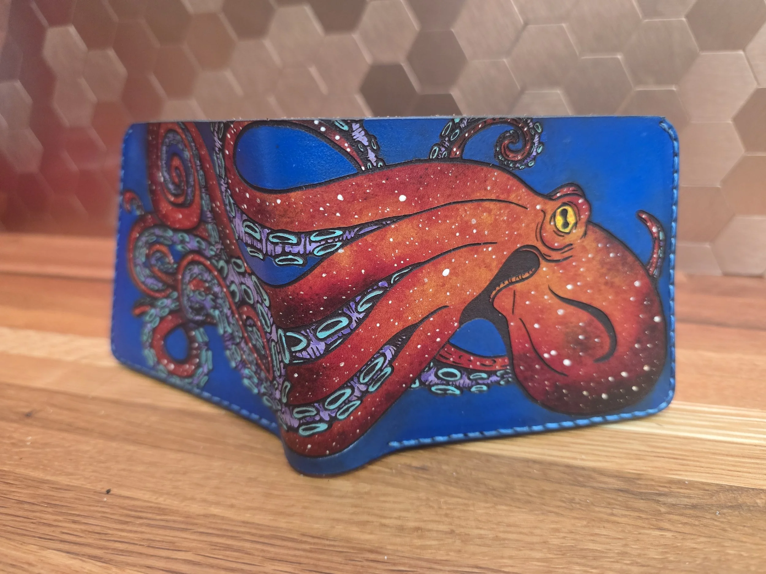 Colorful rectangular wallet with a painted octopus design on a wooden surface