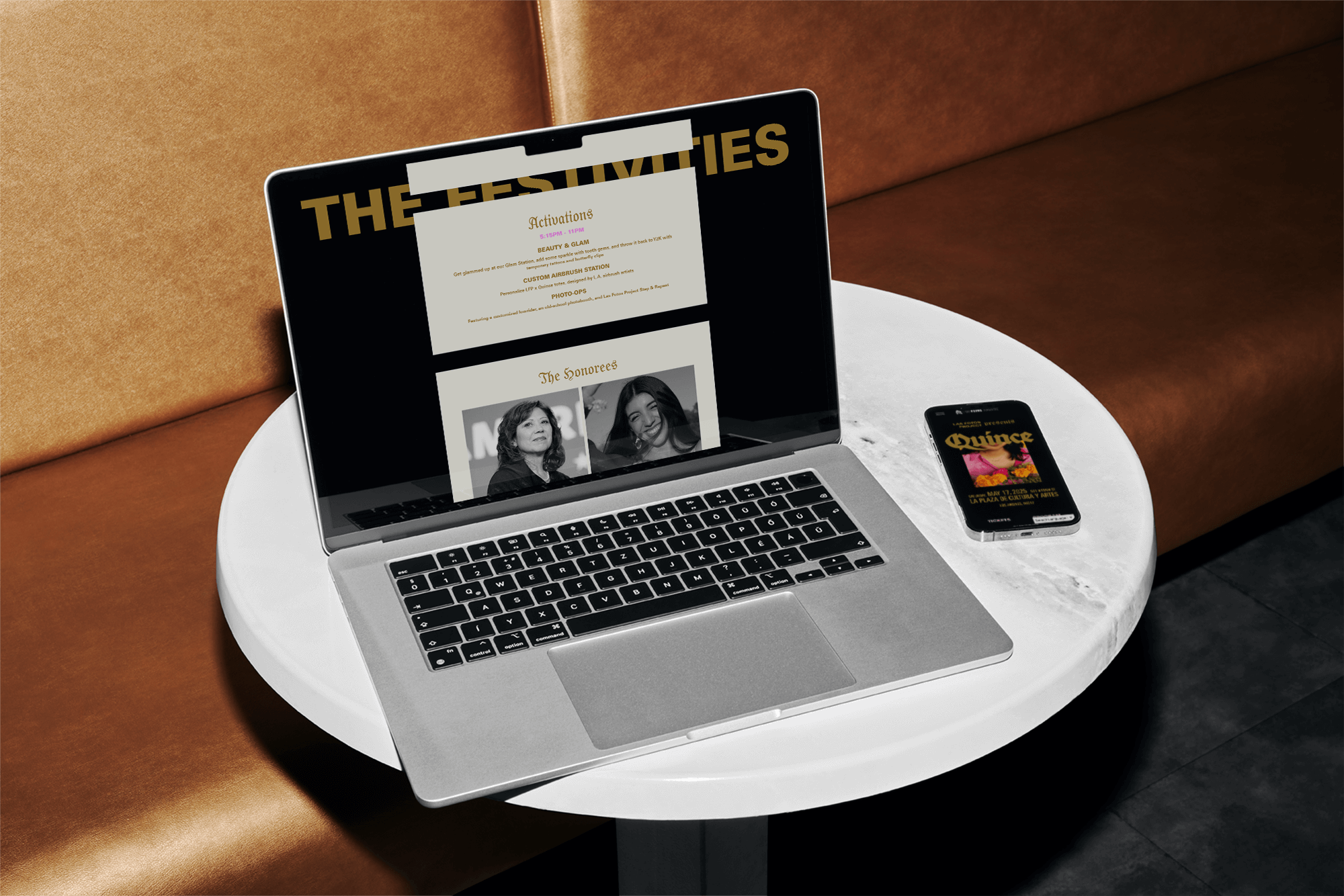A MacBook laptop and a smartphone on a round white table in a room with a brown leather couch. The laptop screen displays a website with event details and photos of two women, and the smartphone shows a colorful poster for an event called 'Quince'.