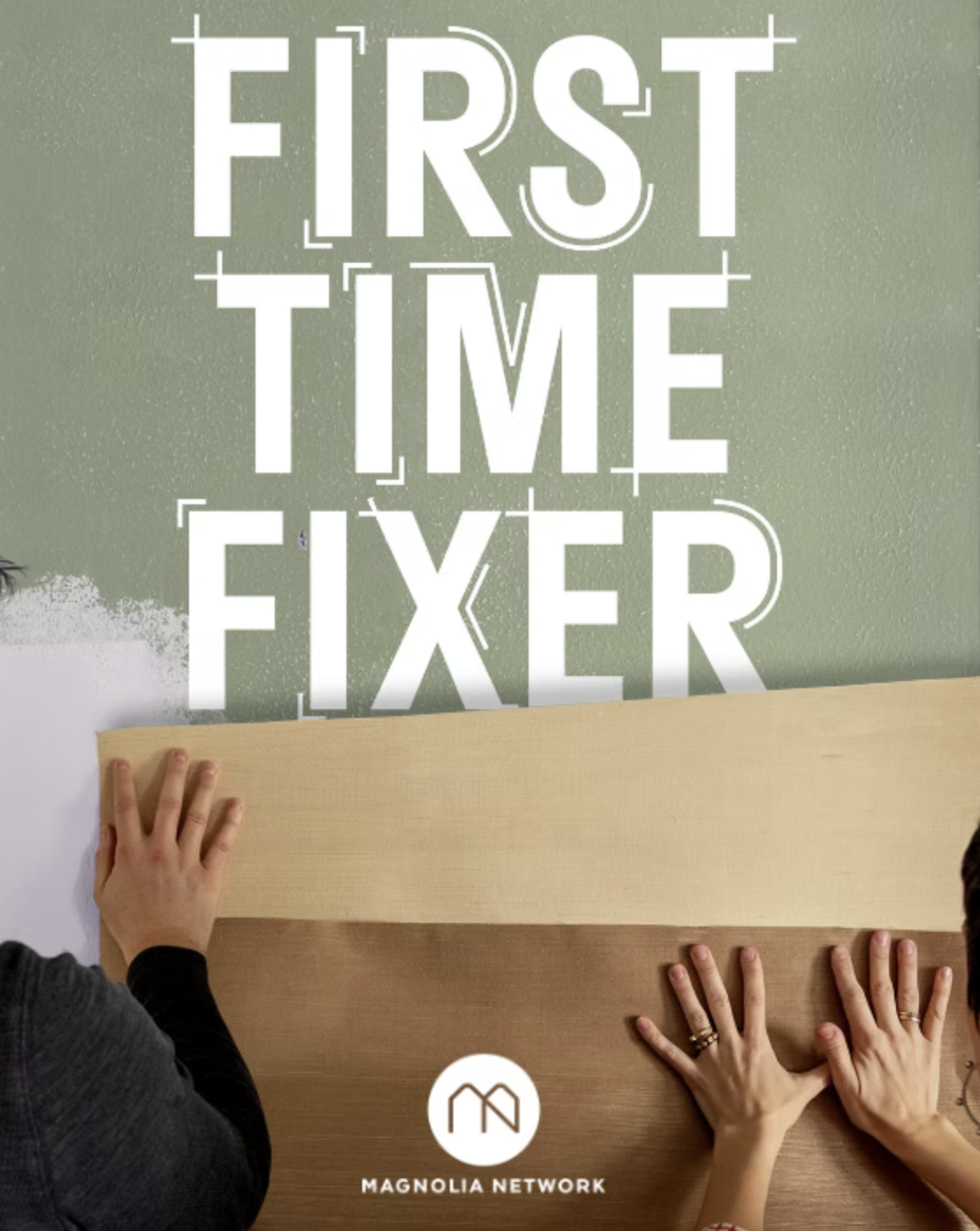 Two individuals are applying a large decal sticker on a wall that reads 'FIRST TIME FIXER' with the logo of Magnolia Network below.