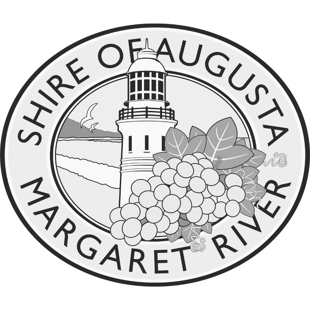 A circular emblem for the Shore of August Margaret River featuring a lighthouse, grapevine with grapes and leaves, and a scenic landscape with birds and hills.