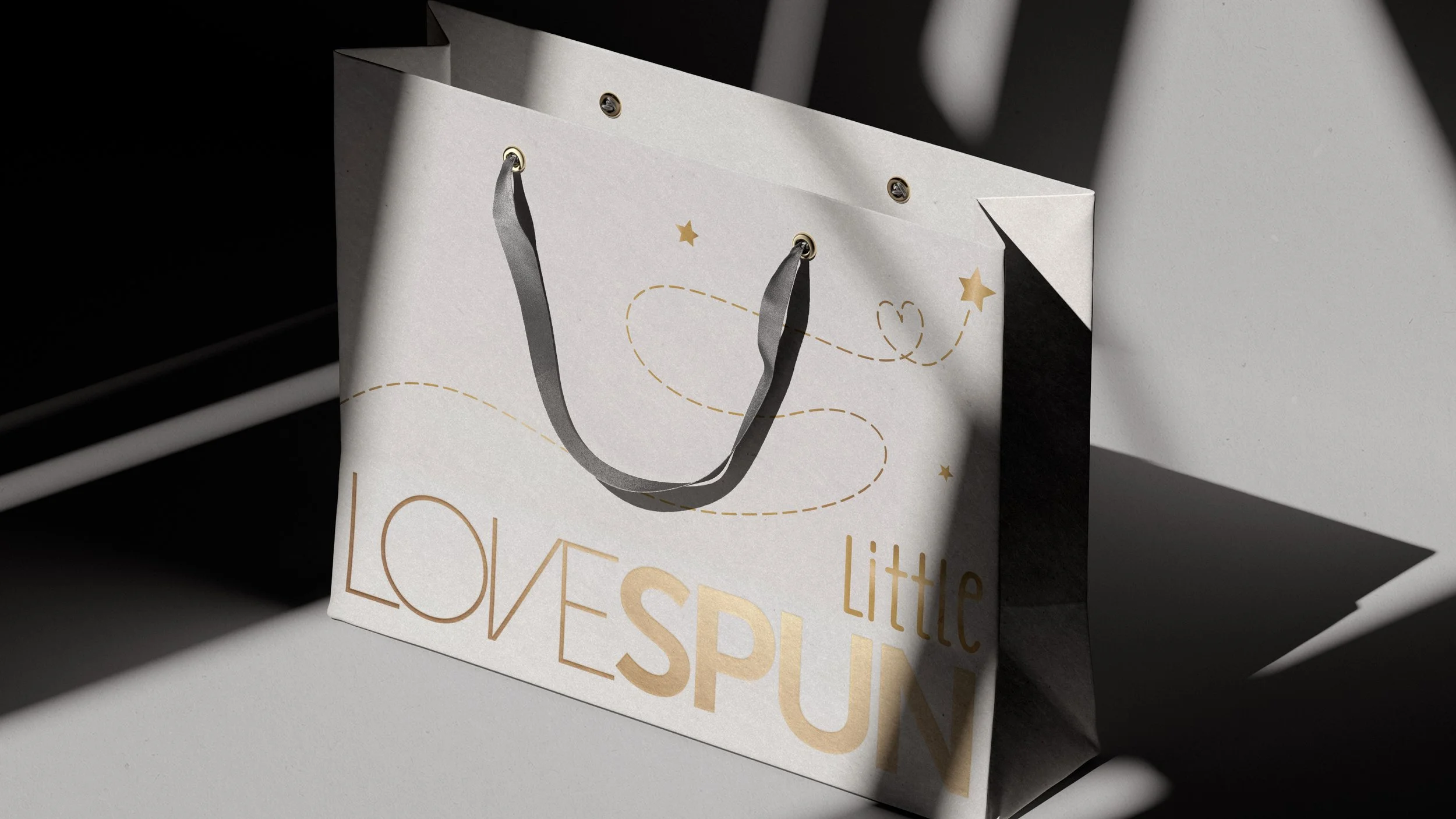 Little Lovespun shoping bag with grey color and gold font of the brand name and stars