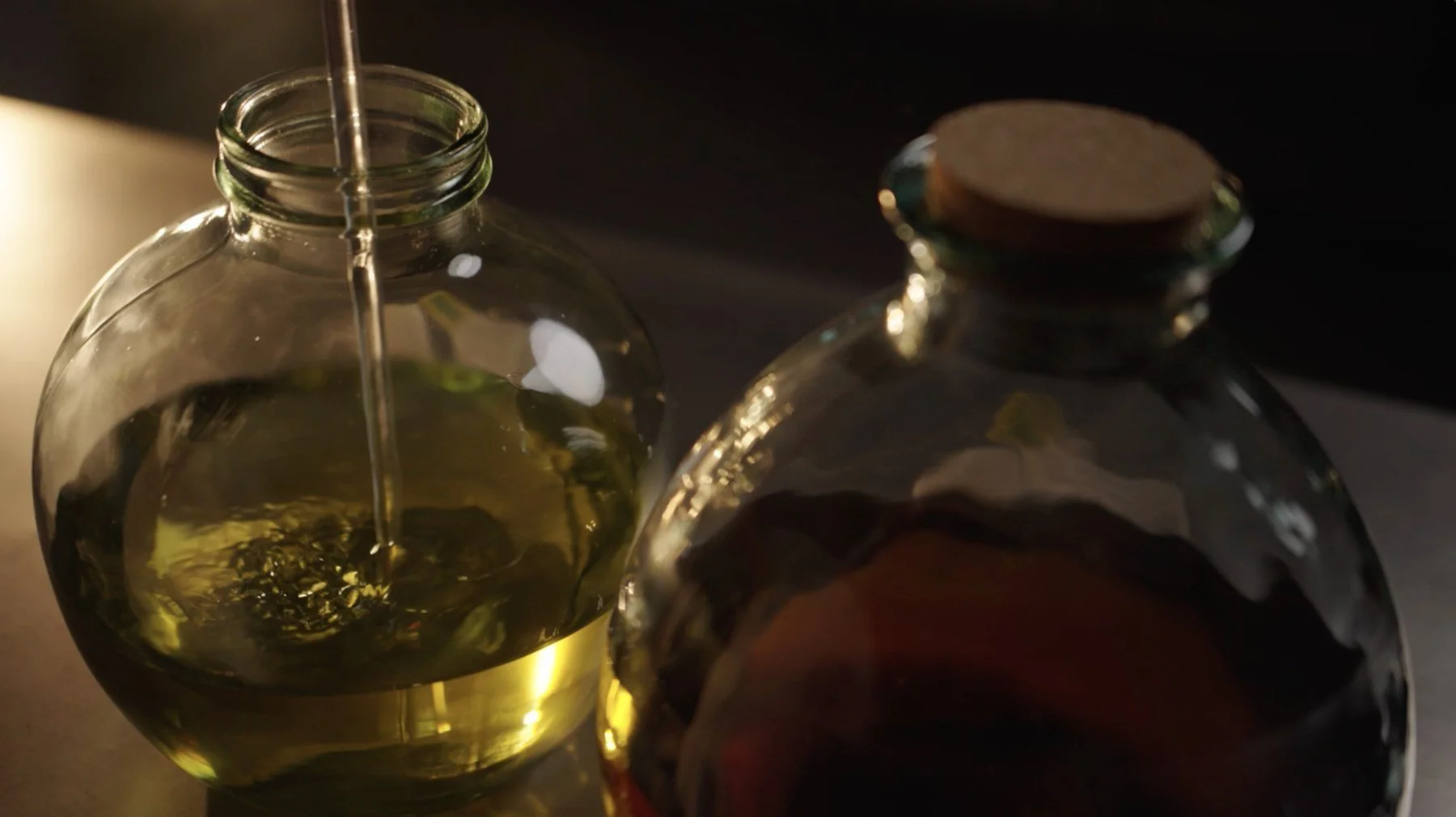 Glazen flessen met aromatische olie in warm licht