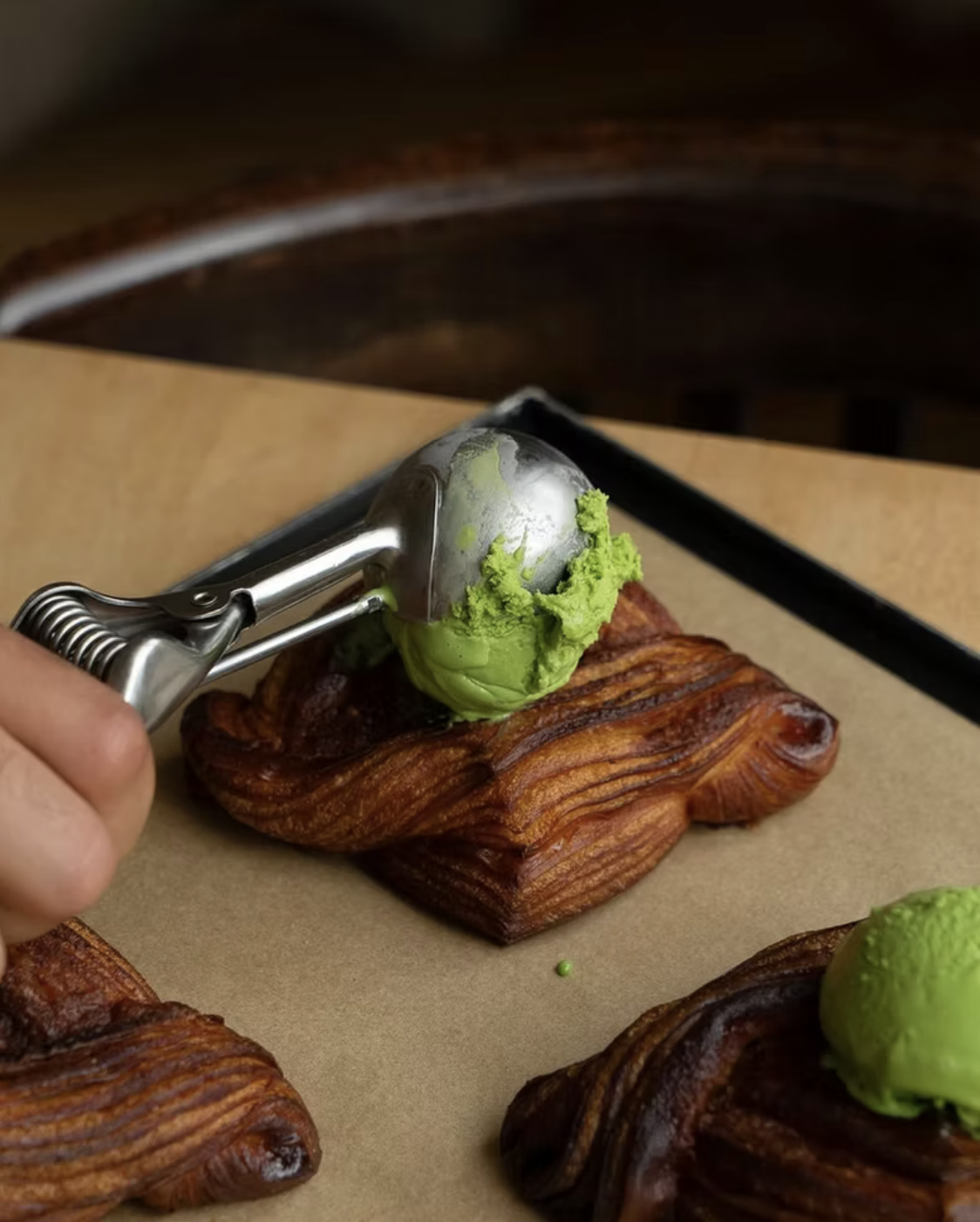 A scoop of green matcha ice cream with a waffle pastry.