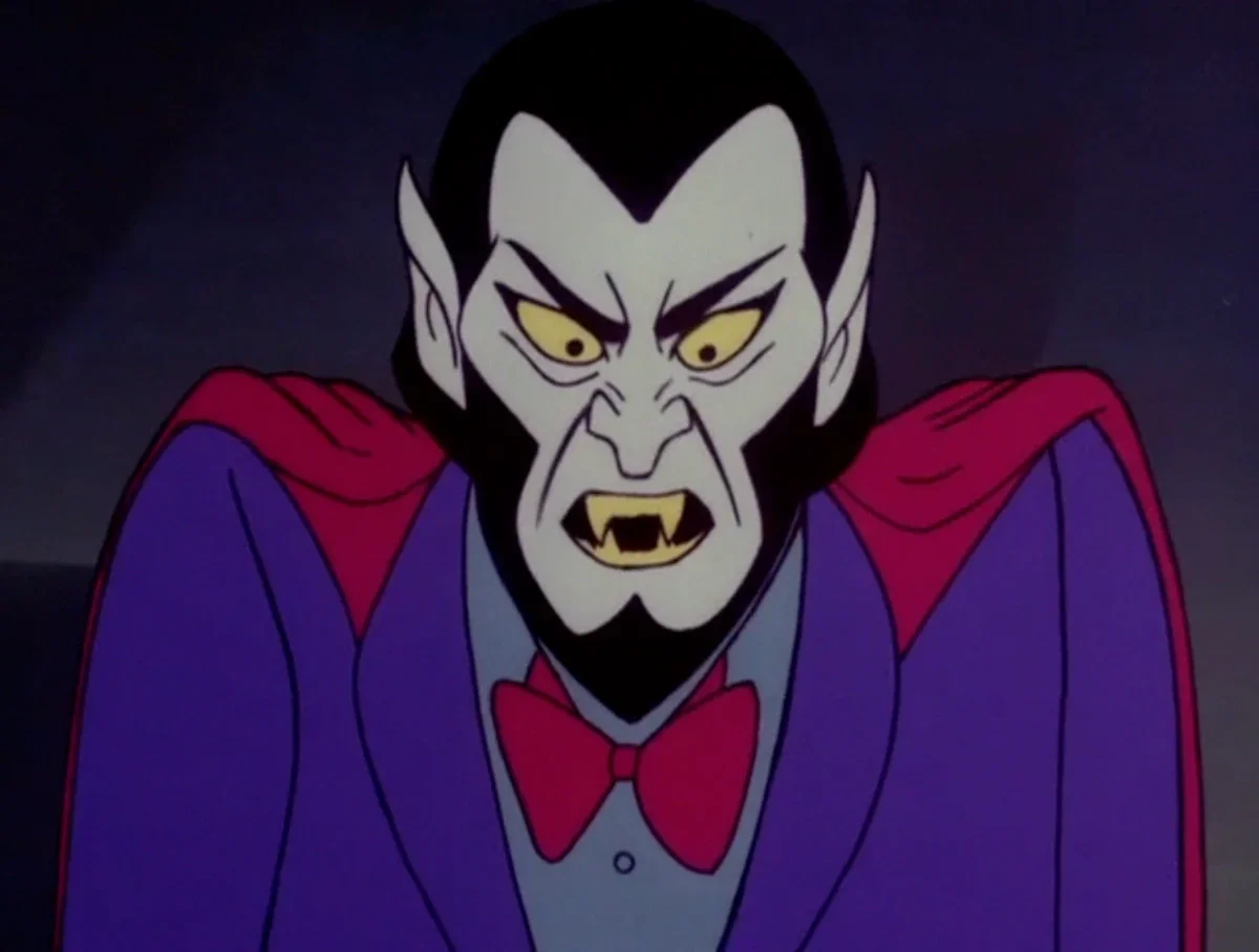 An animated vampire character with pale skin, pointy ears, bright yellow eyes, sharp fangs, black hair, wearing a purple suit with a red bow tie and a red cape, looking angry.