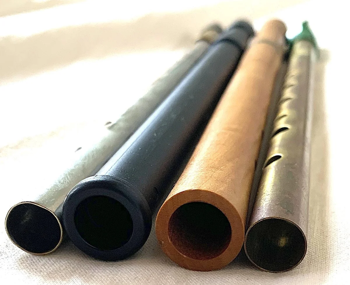 Vier Tin Whistles von unten, Materialien Metall, Messing, Holz und Kunststoff im Vergleich