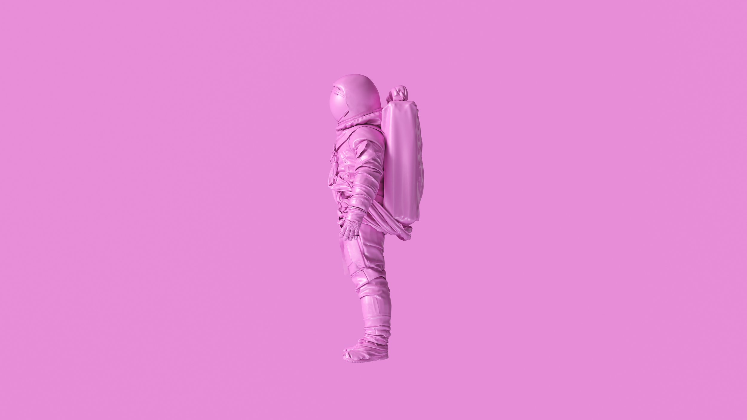 Pink astronaut suit standing against pink background.