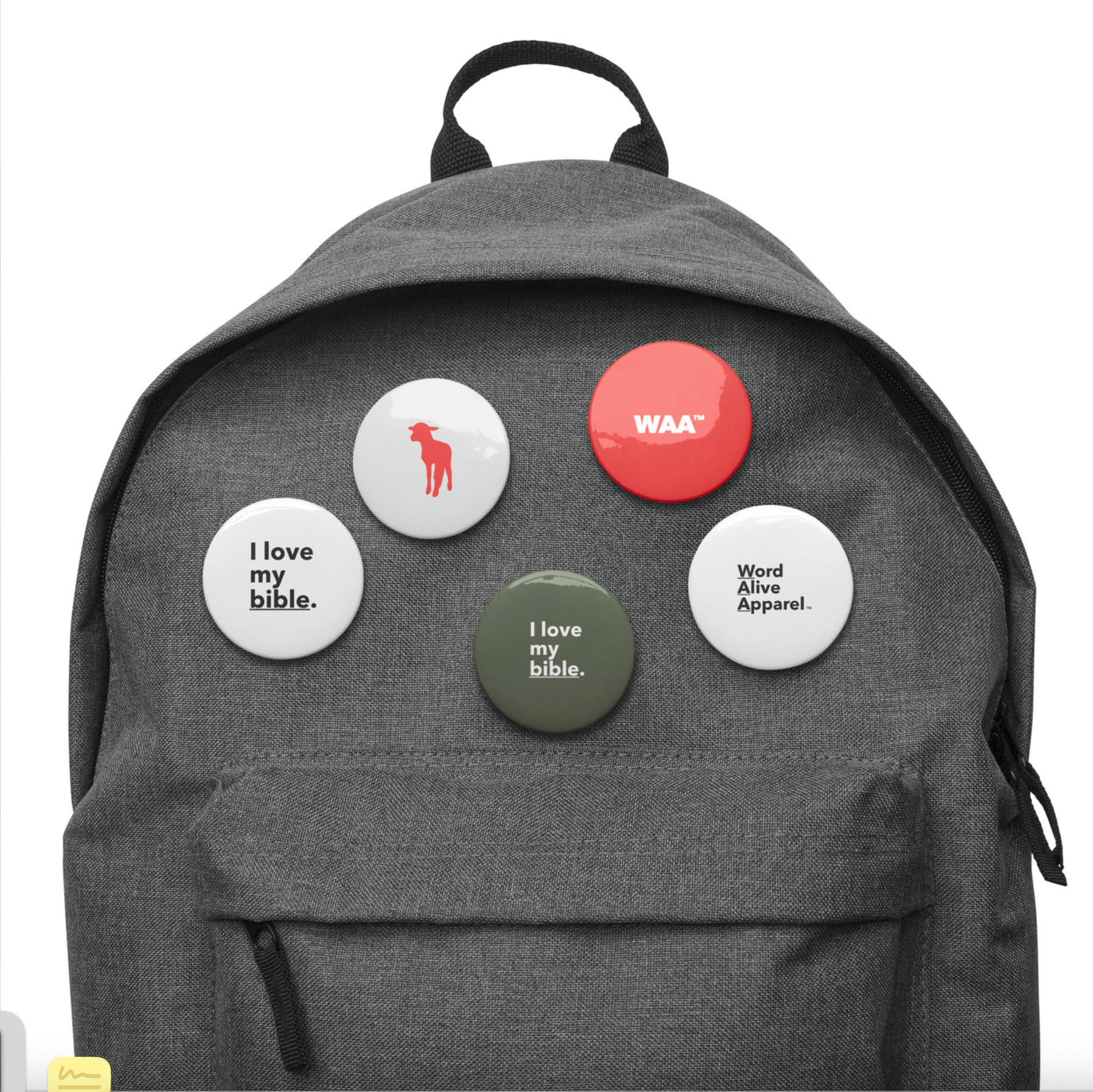 Gray backpack with five round buttons attached to the front. The buttons include a white one with a red dog silhouette, a red one with white 'WAA,' a white one with black text 'I love my bible,' a white one with black text 'Word Alive Apparel,' and an olive green one with white text 'I love my bible.'