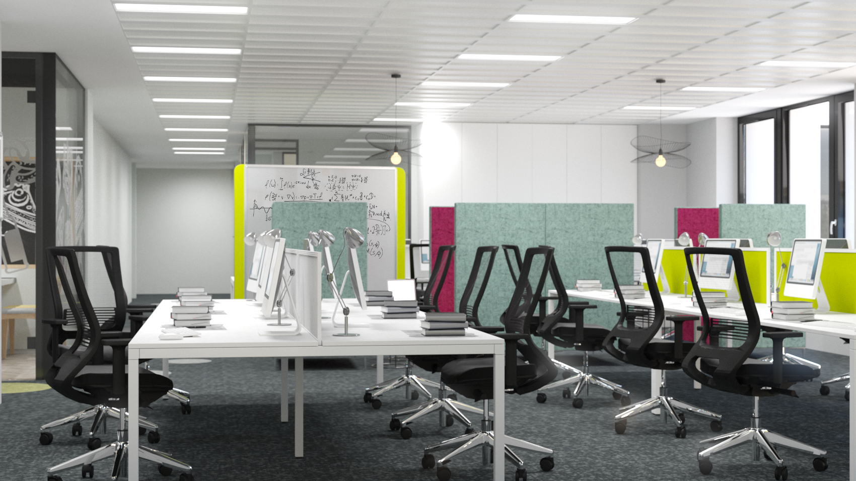 Empty modern office space with multiple workstations, black ergonomic chairs, white desks, computer monitors, stacks of books, and colorful partition panels, with large windows providing natural light.