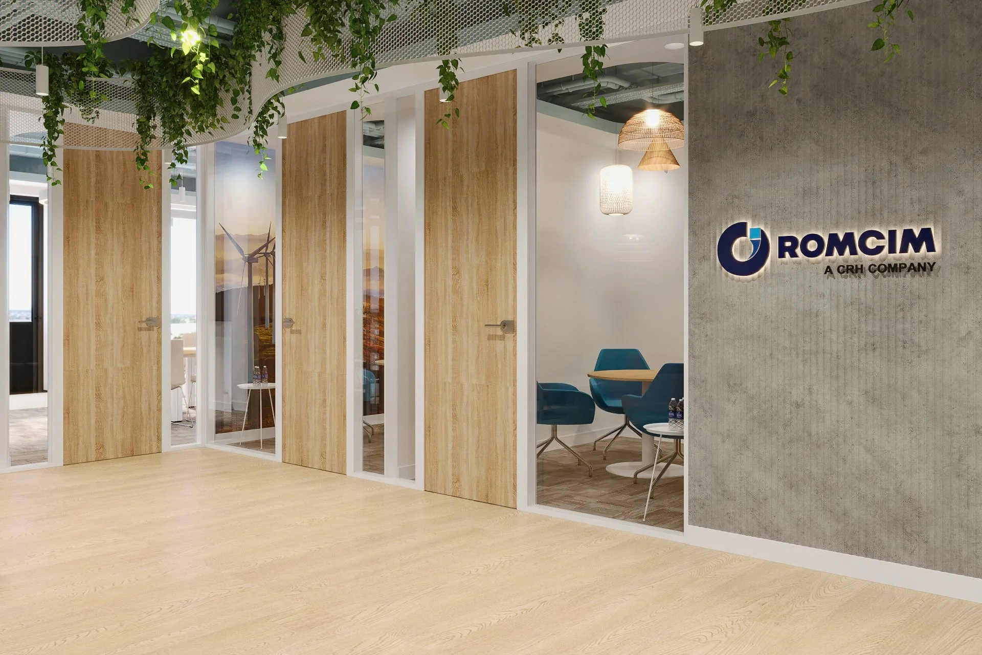 Modern office reception area with wooden and glass doors leading to meeting rooms, a concrete wall with a company's logo reading 'ROMCIM A CRH COMPANY,' and hanging pendant lights.