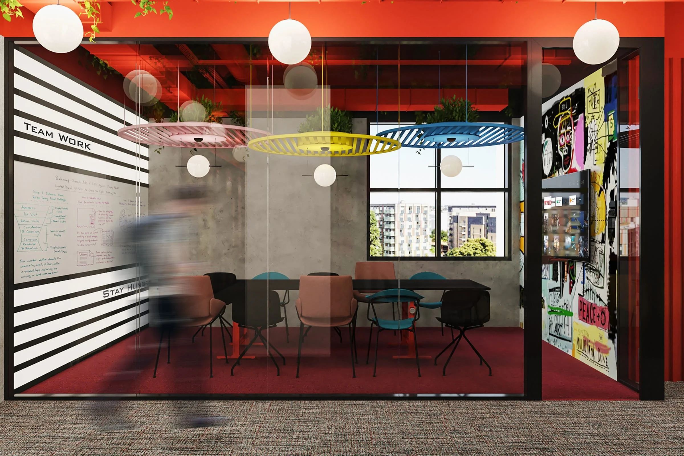 Modern office meeting room with glass walls, colorful pendant lights, a window view of city buildings, and artwork on the walls.