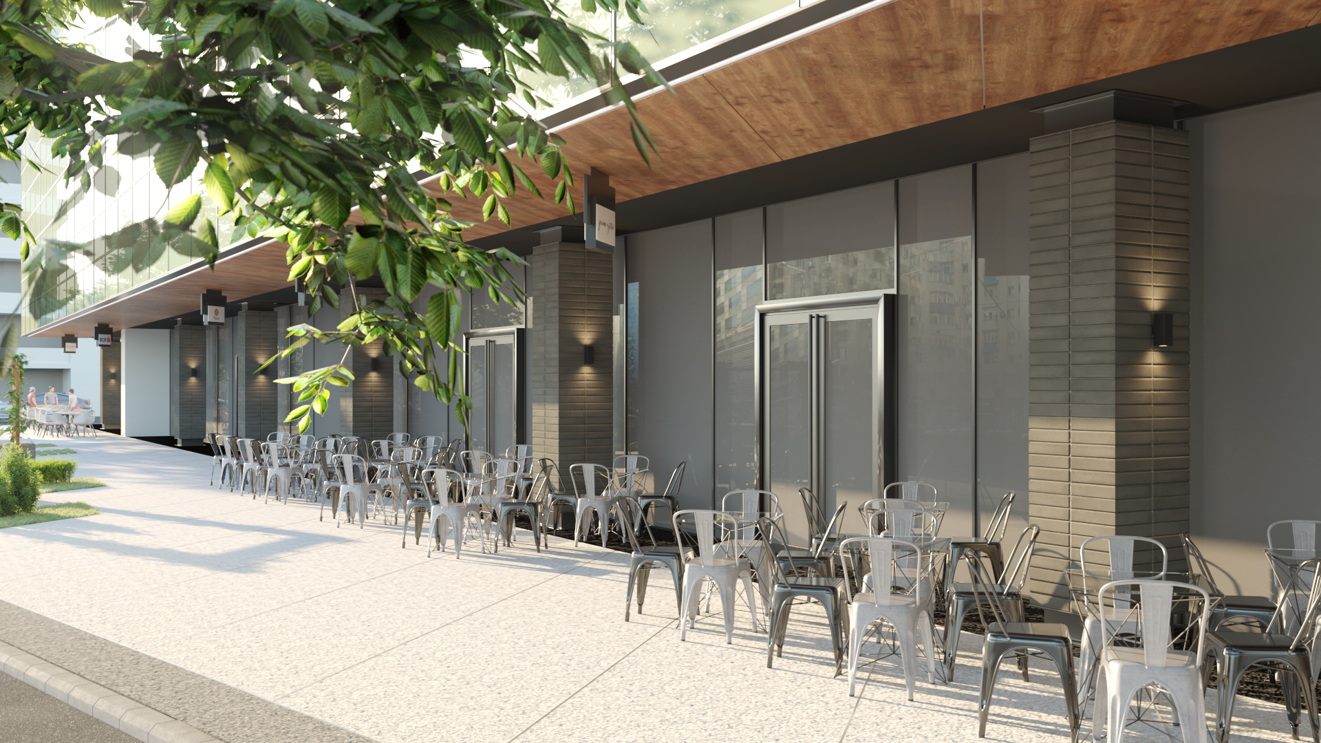Empty outdoor dining area with metal chairs and tables in front of modern glass building, tree in the foreground.