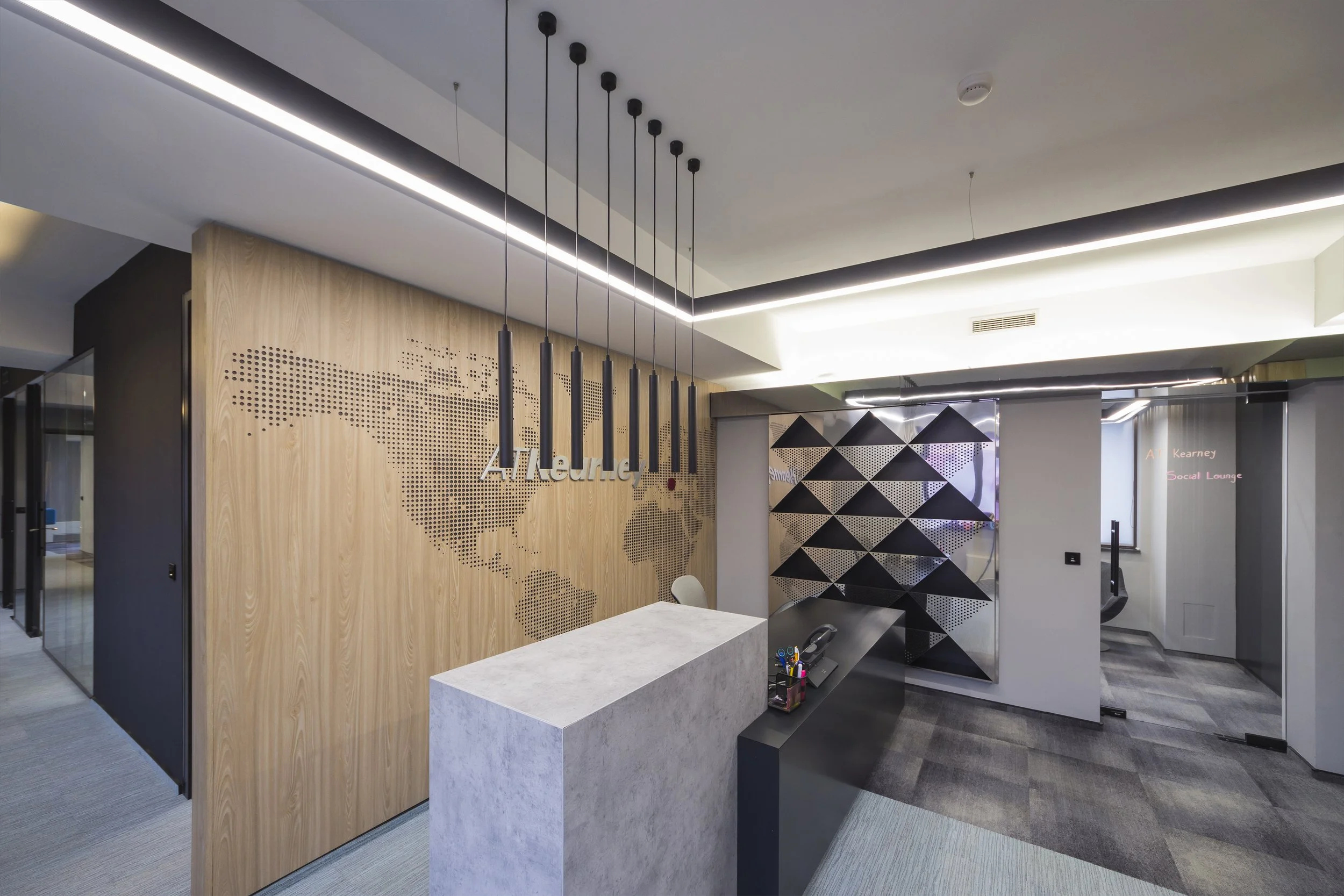 Modern office reception area with wooden wall displaying a dotted world map and the word 'Attrorney,' sleek ceiling lights, and a black and gray geometric partition.