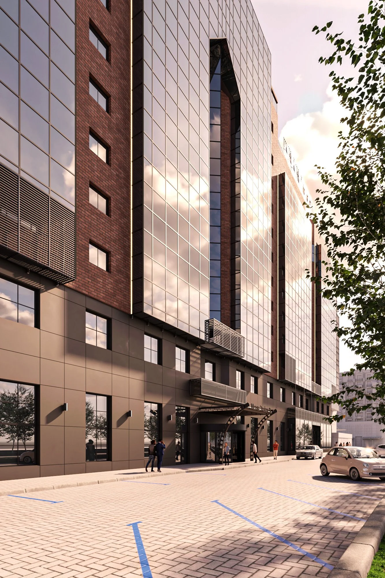 A modern multi-story building with reflective glass windows, brick accents, and an entrance with a canopy. There are cars parked and people walking in a parking lot in front of the building, with trees lining the area and a partially cloudy sky reflected in the windows.