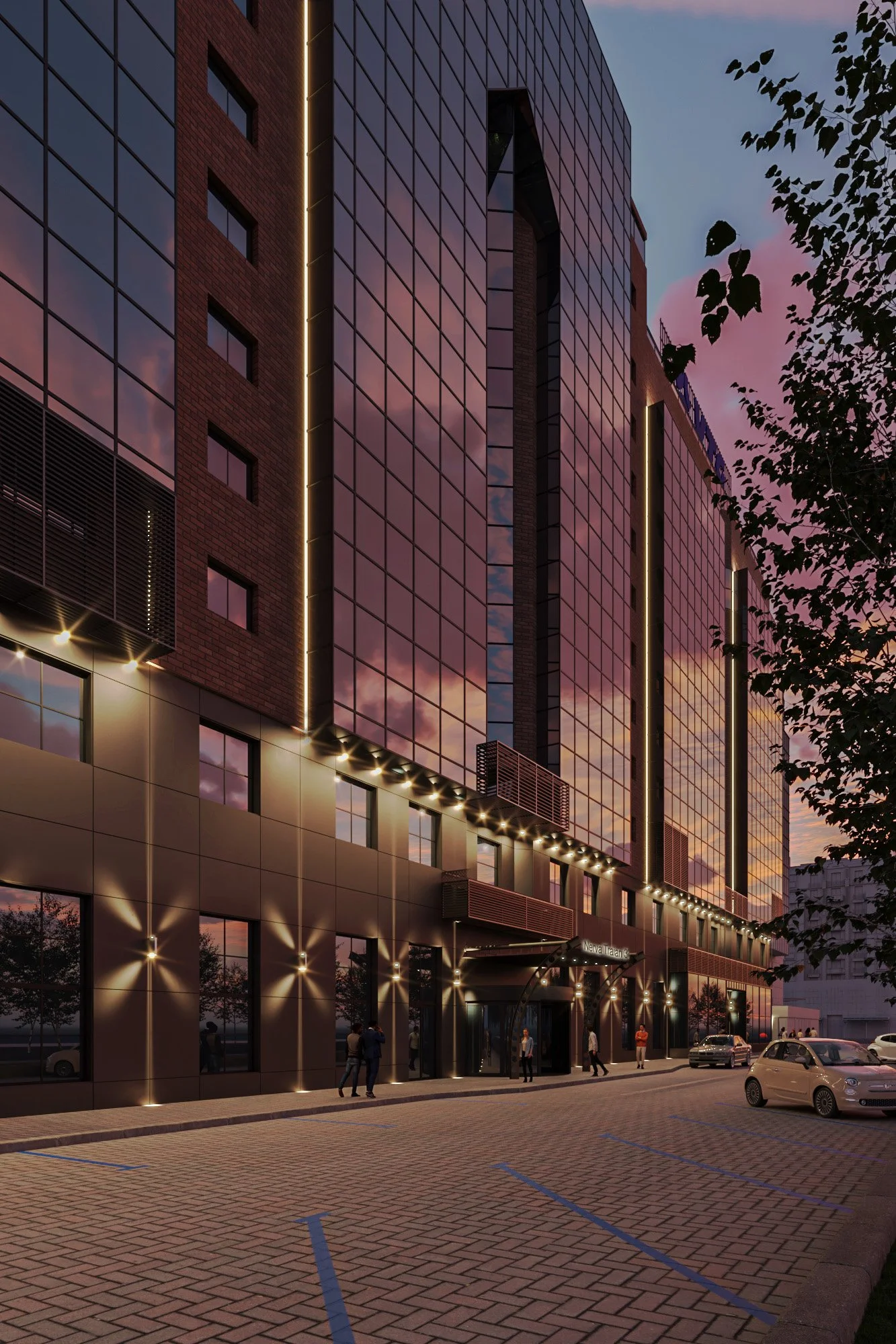 Nighttime view of a modern multi-story building with glass and brick exterior, illuminated with exterior lights and reflections of the pink and purple evening sky, with a few people walking on the sidewalk and cars parked in front.