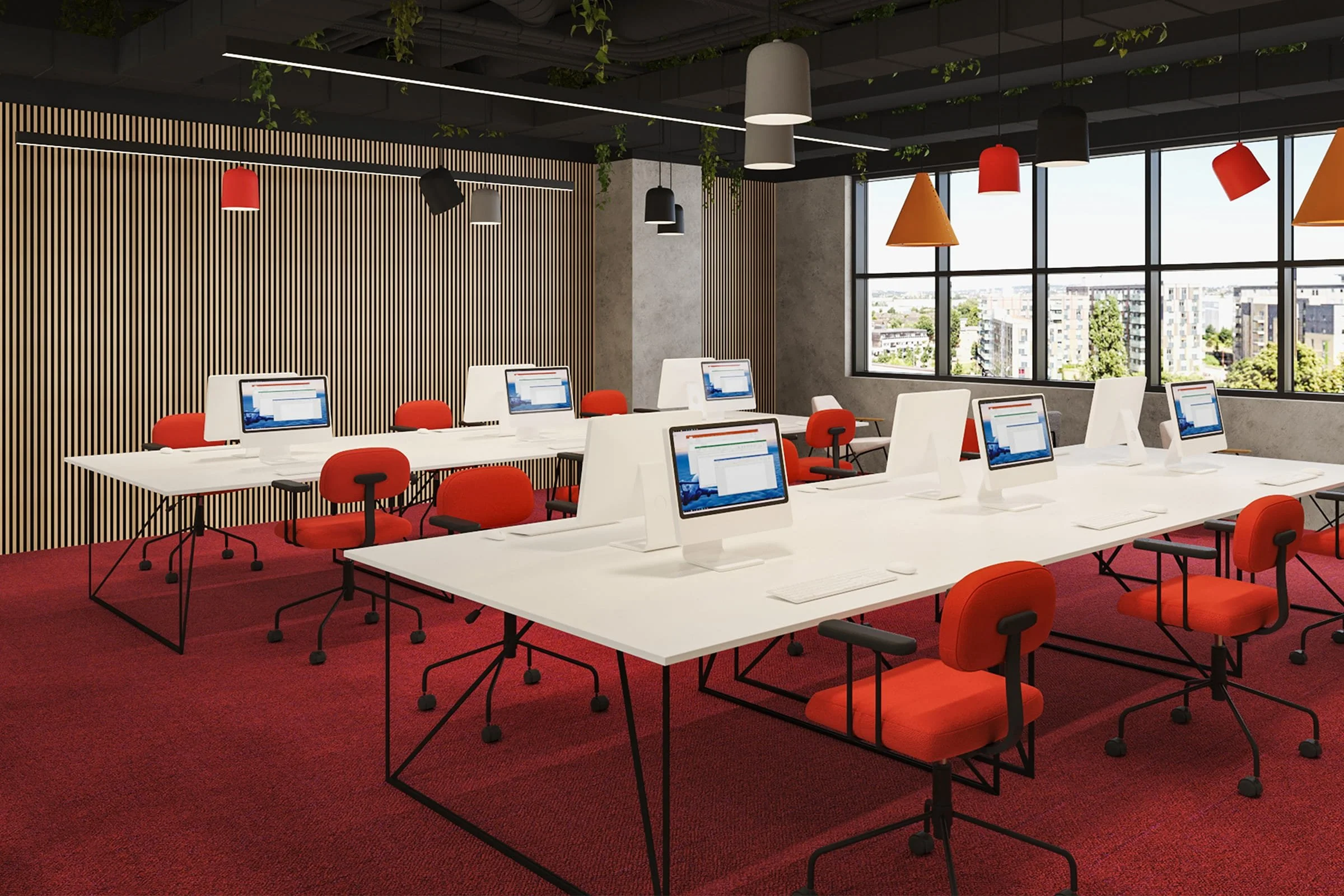 Modern computer lab with white desks, orange chairs, desktop computers, large windows, and colorful pendant lighting.