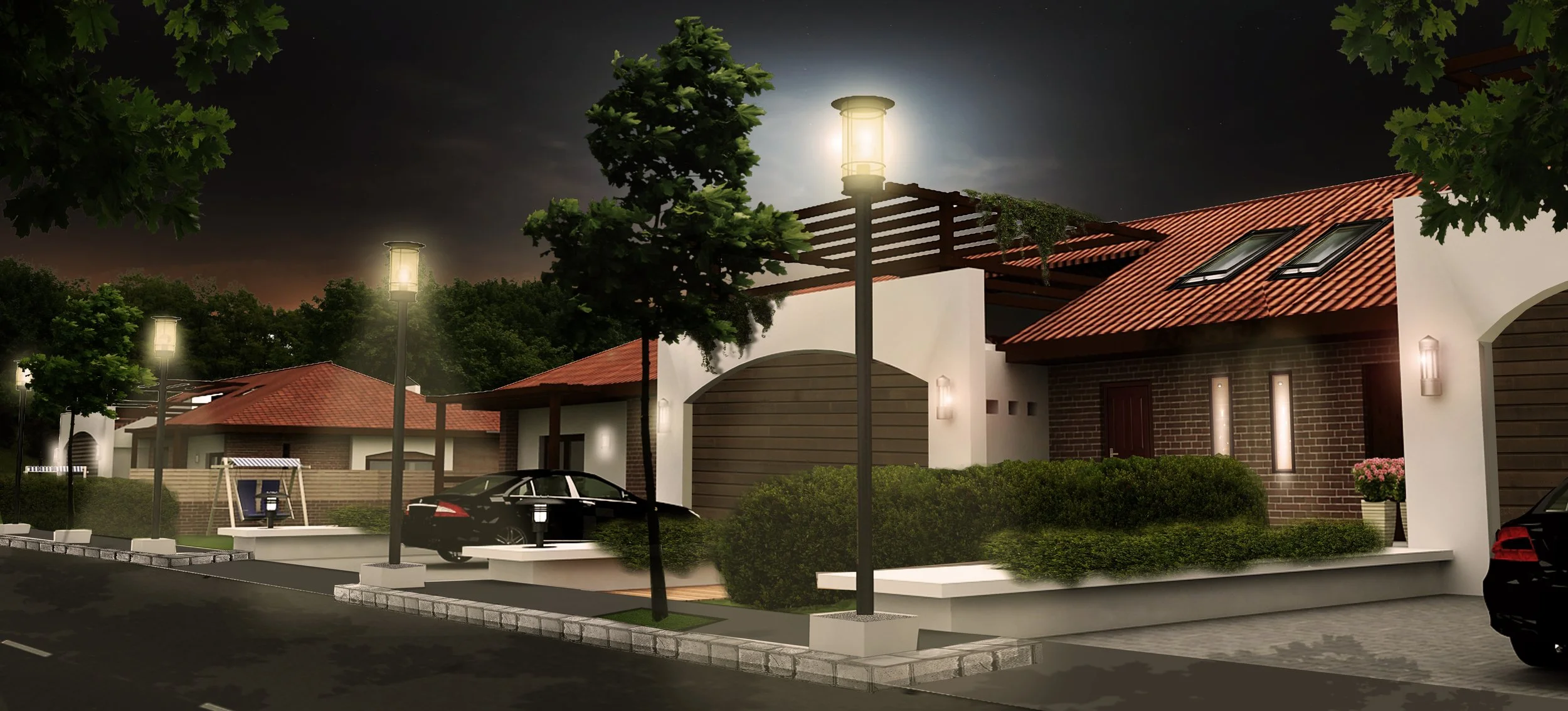 Night view of a modern residential neighborhood with street lamps, parked cars, trees, and houses with red-tiled roofs.