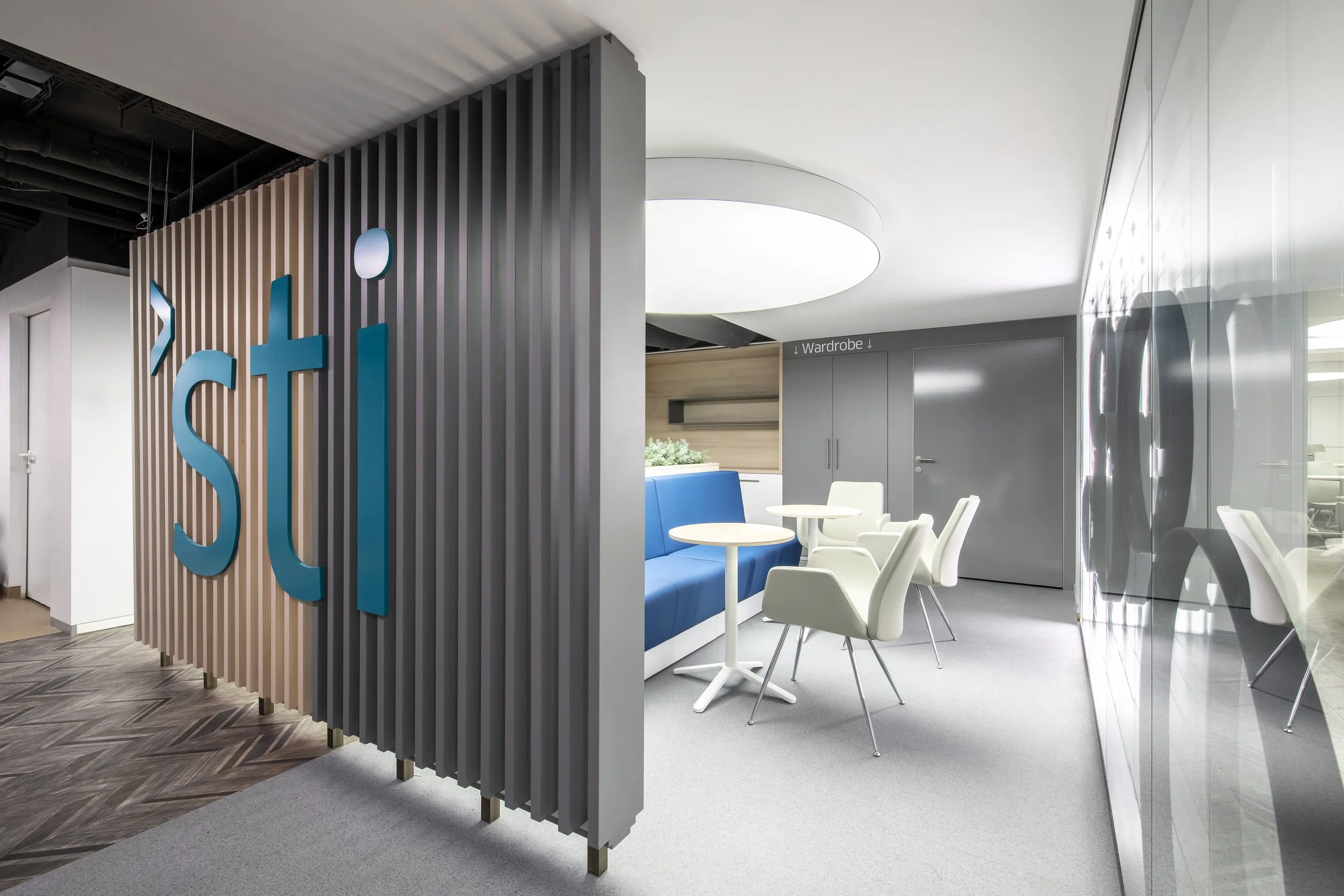 Interior of a modern hospital break area with seating, tables.