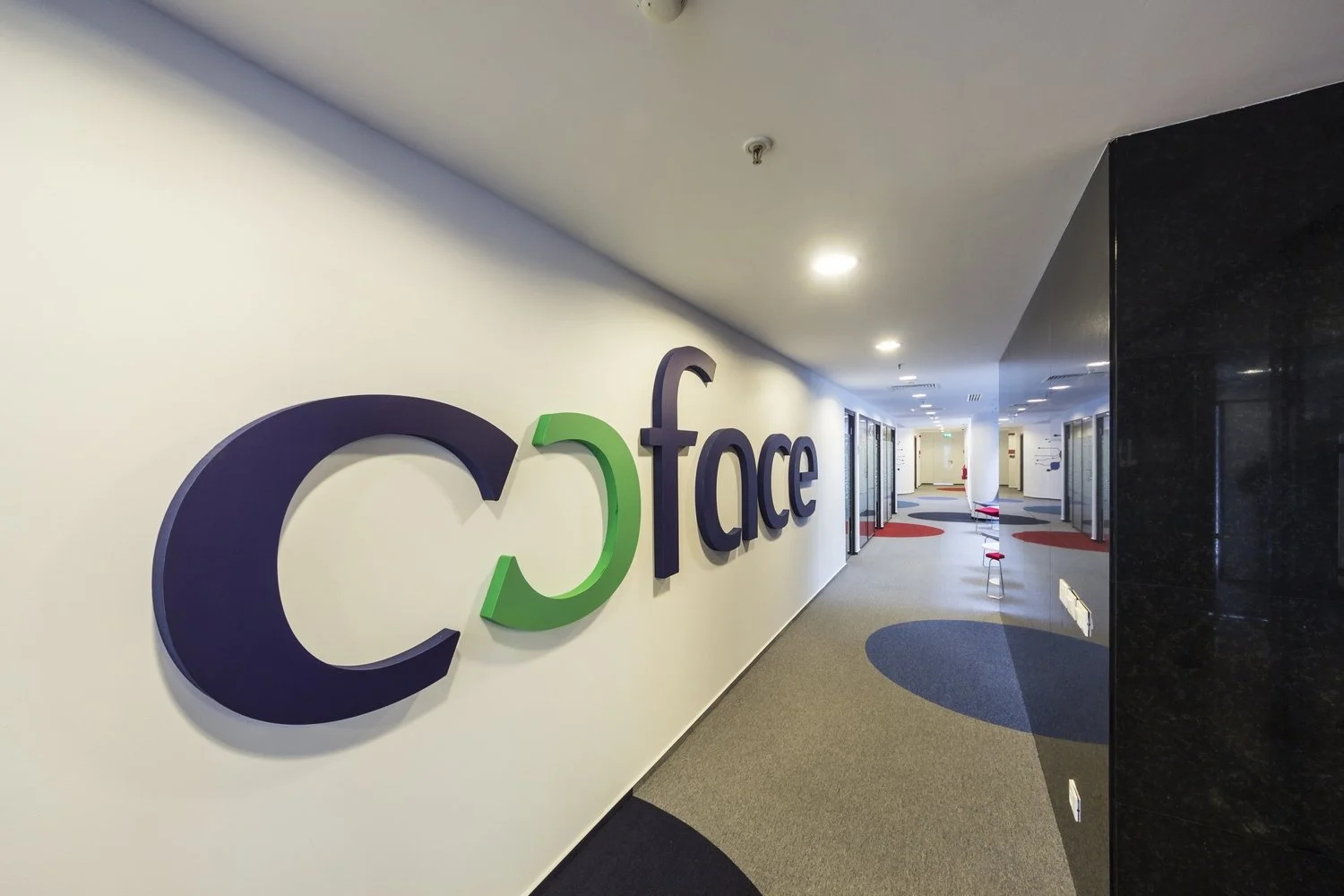 Hallway of the Credit Agricole building with the company's logo on the wall.