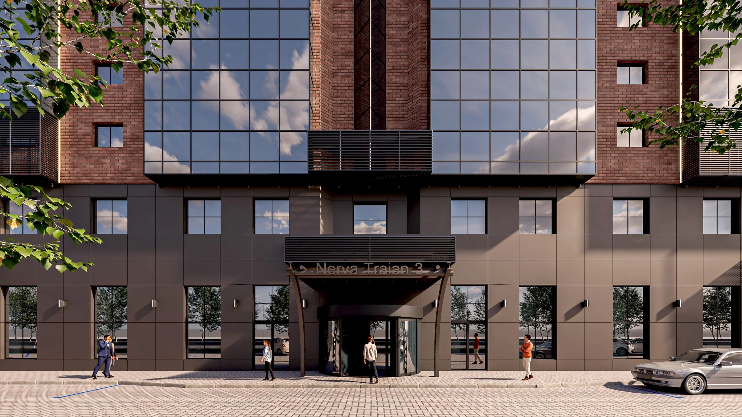 Modern multi-story building with glass windows reflecting the sky and clouds, brick accents, and a ground level entrance with people walking, parked cars, and trees in the surroundings.