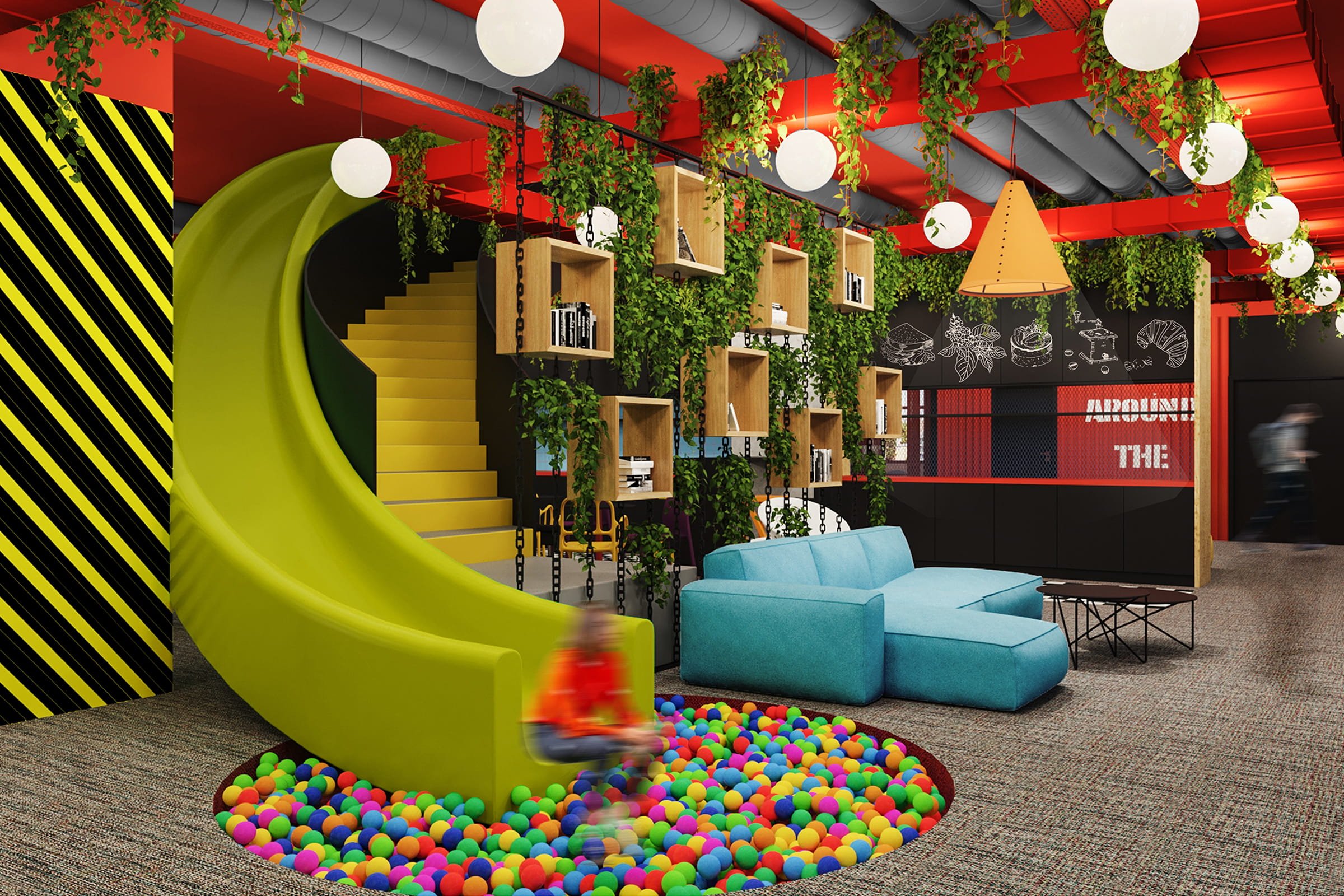 A colorful indoor play area with a green slide leading into a ball pit filled with multicolored plastic balls. To the right, there's a light blue sectional sofa and a small black coffee table. Behind the sofa, a wall features wooden shelves with books and greenery hanging from chains, with a black chalkboard wall with white illustrations and the partially visible text "AROUND THE". The ceiling has red beams, white spherical lights, and hanging plant decorations.