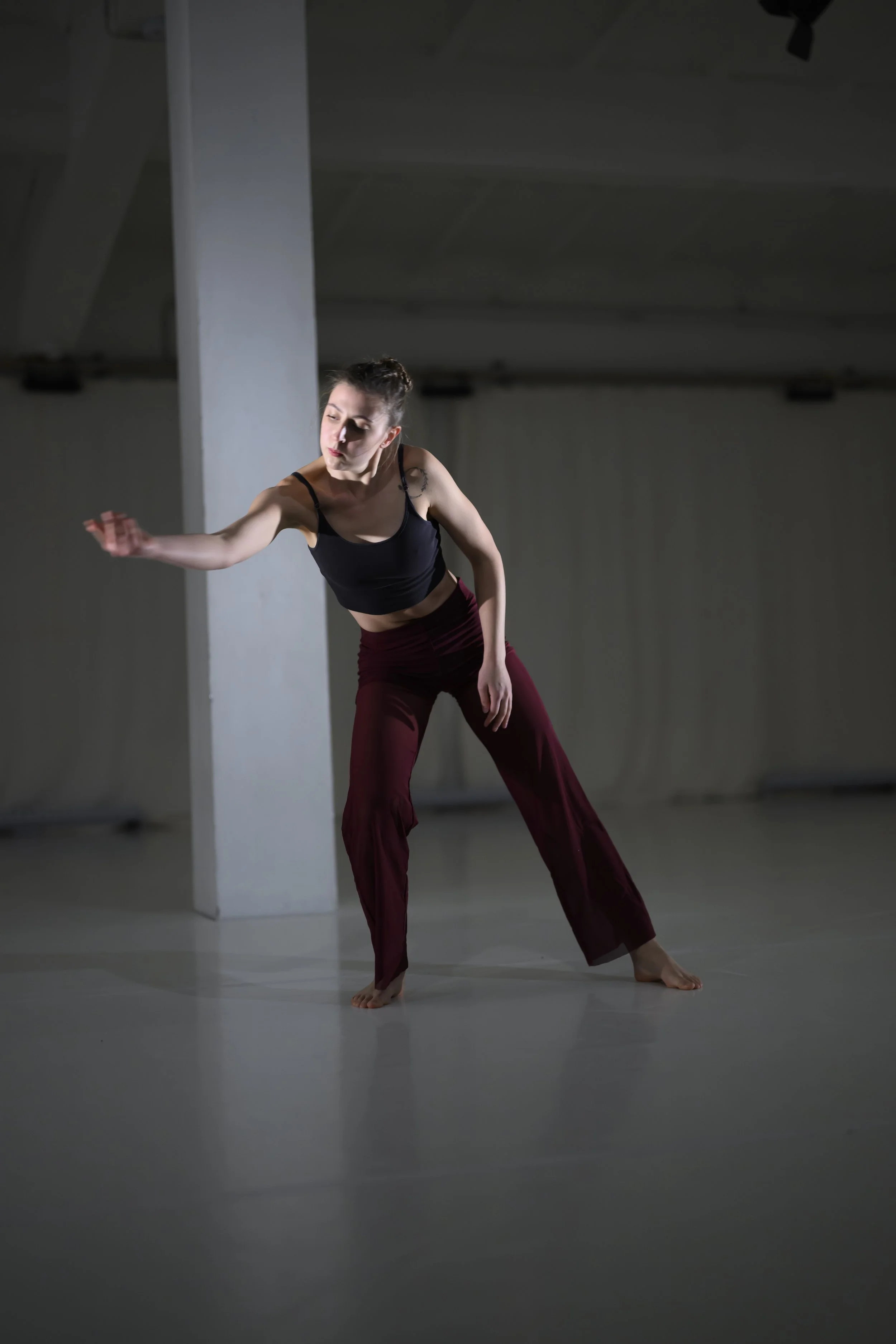 Tänzerin in einem dunklen Raum in einer Tanzhaltung