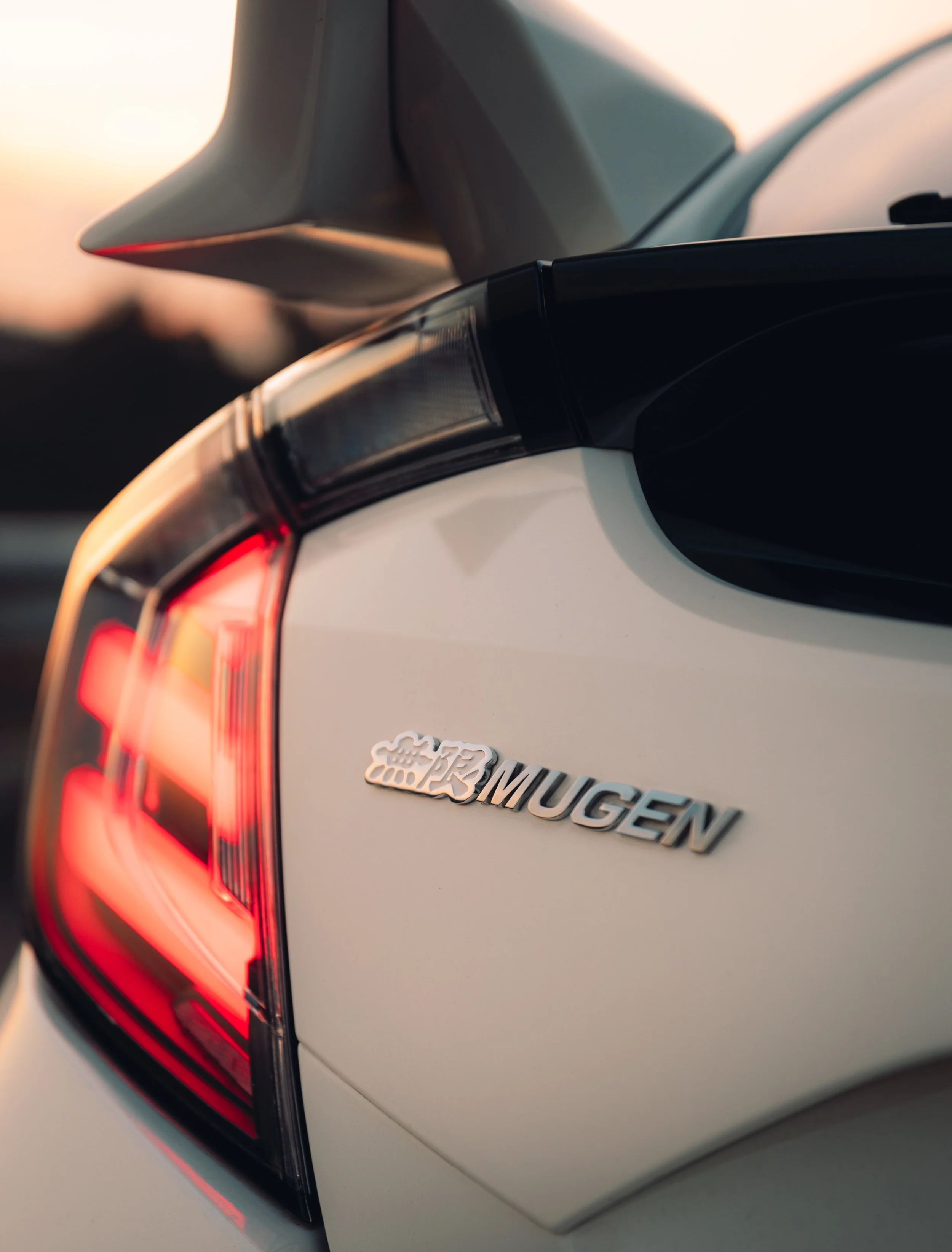 Close-up of the rear of a white BMW i3 Mugen electric car, with a focus on the taillight and badge.