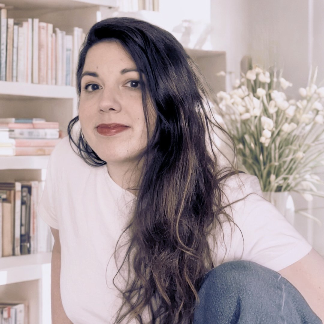Mylène Thisse, ICF-trained self-leadership coach for women, sitting by her bookshelf