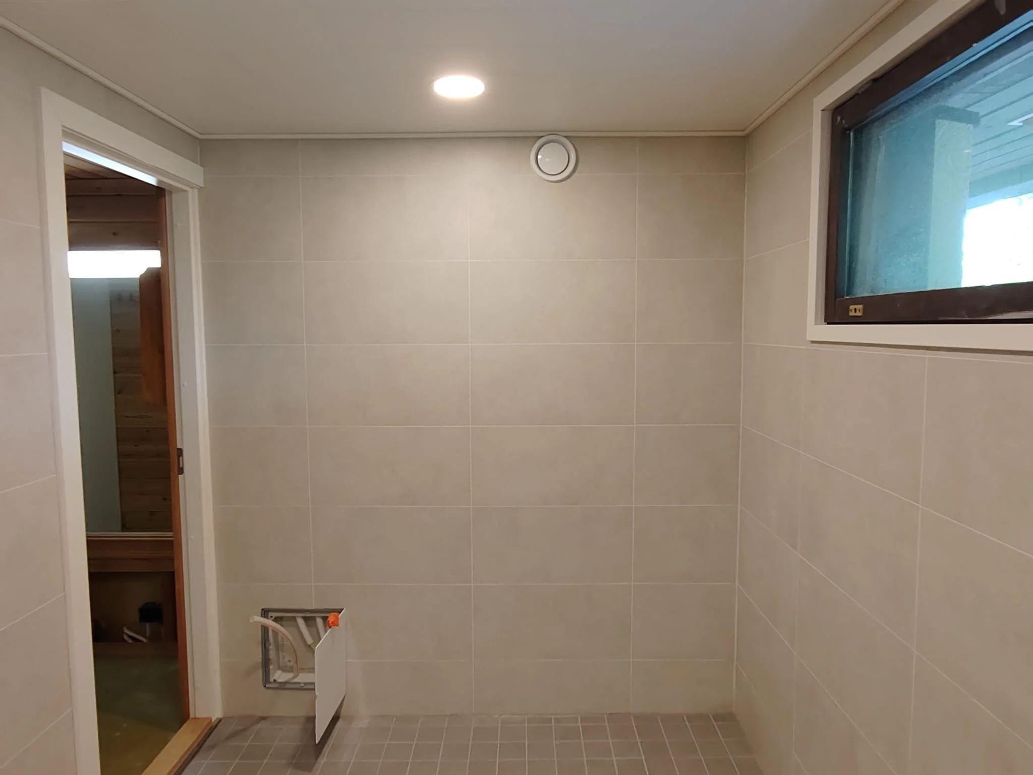 Kylpyhuone tila, jossa vastavalkaisut seinissä, ikkunassa ja lattialla.