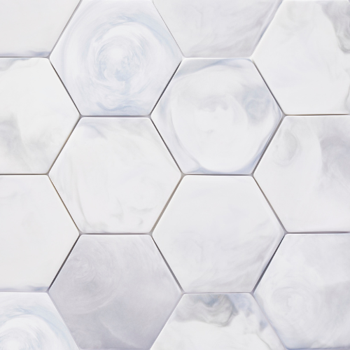 Hexagonaaliset valkoiset laatat, joissa harmaasävyinen marmorikuviointi.