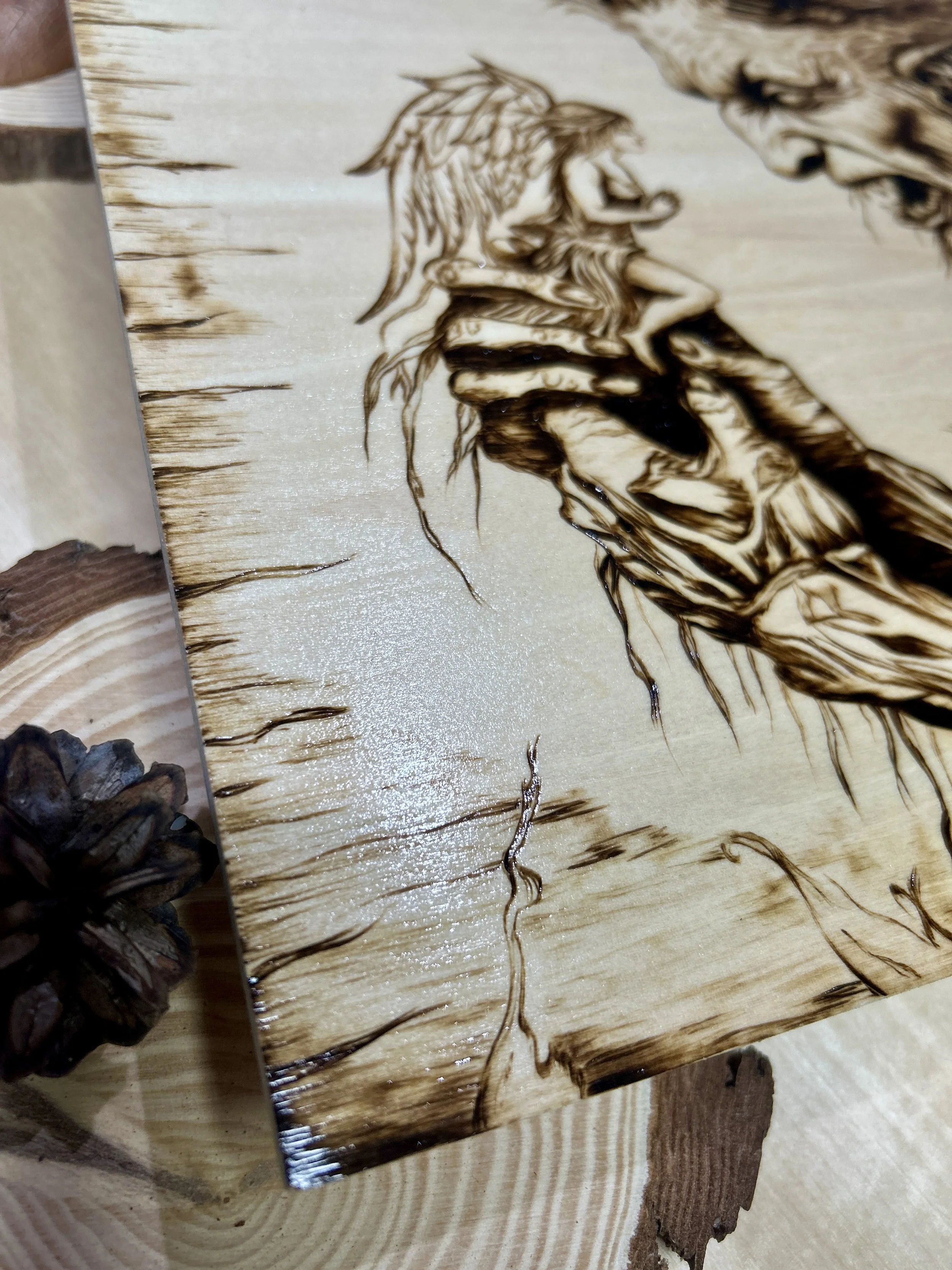 Collection of wood-burned pyrography artworks featuring angels and demons, showcasing handcrafted fantasy art in unique, artisan, one-of-a-kind designs and decor