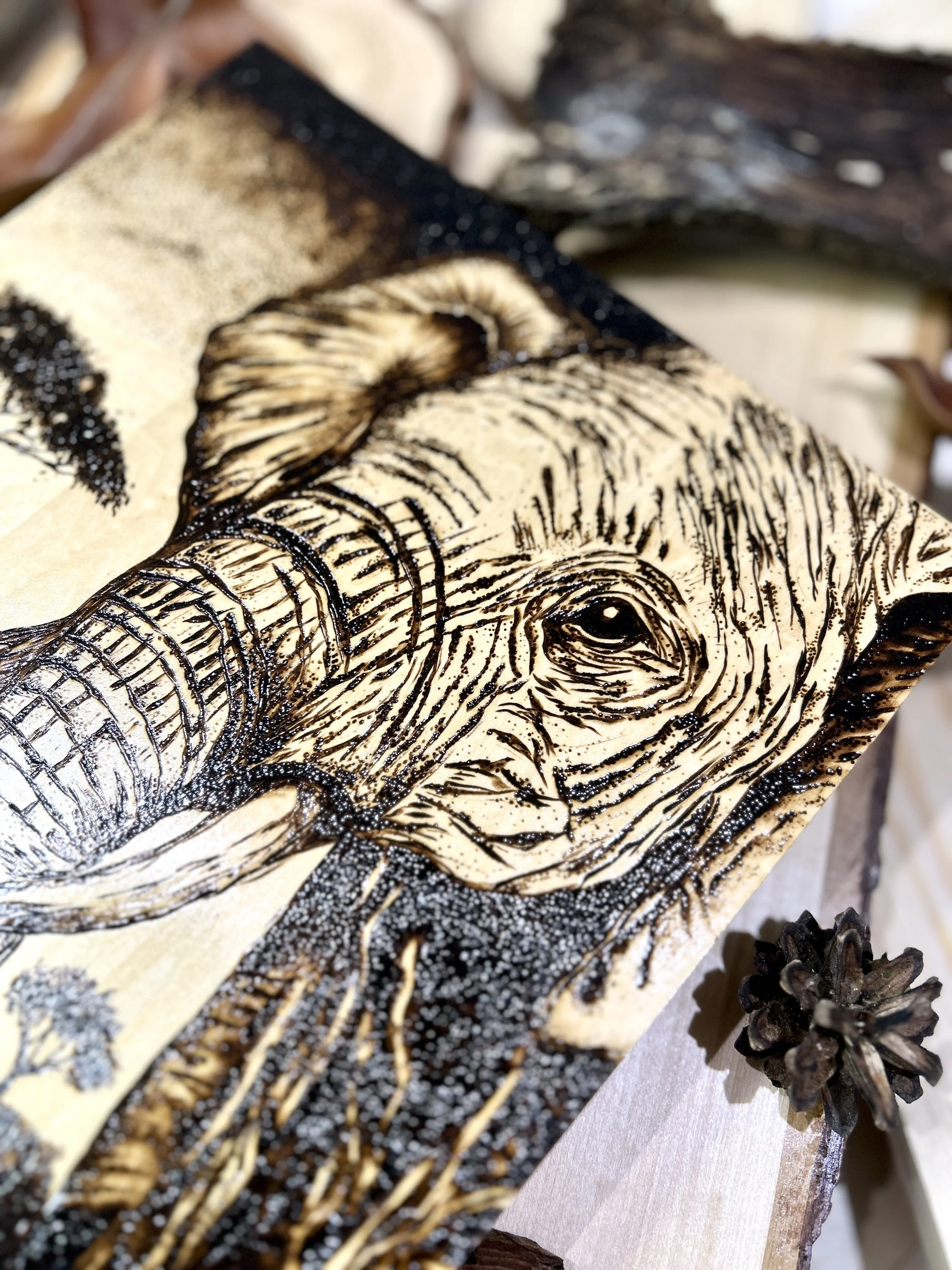 Collection of wood-burned pyrography artworks showcasing handcrafted fantasy art in unique, artisan, one-of-a-kind designs and decor, featuring detailed Savanna Reverie elephant scenes on natural wood