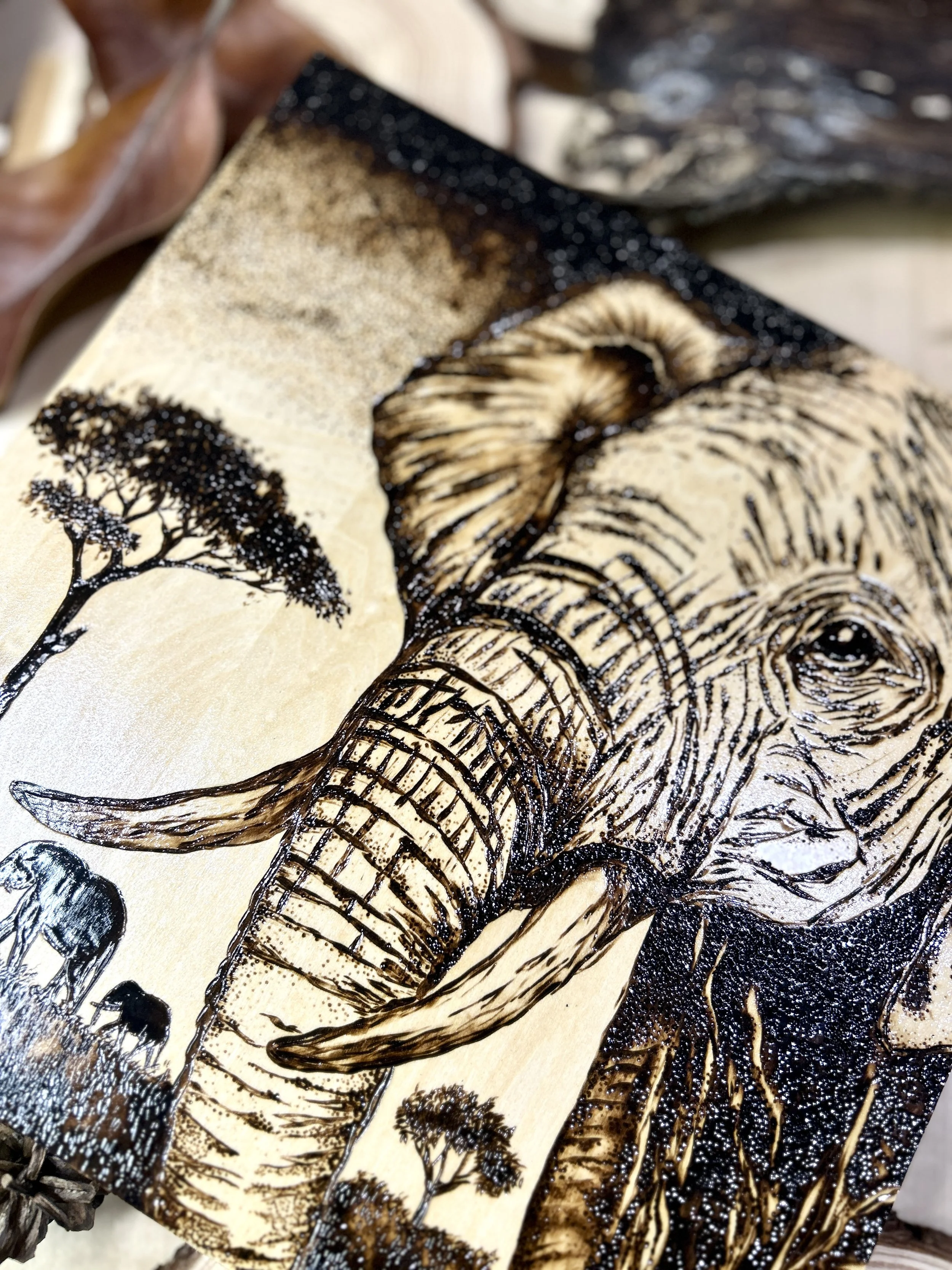 Collection of wood-burned pyrography artworks showcasing handcrafted fantasy art in unique, artisan, one-of-a-kind designs and decor, featuring detailed Savanna Reverie elephant scenes on natural wood