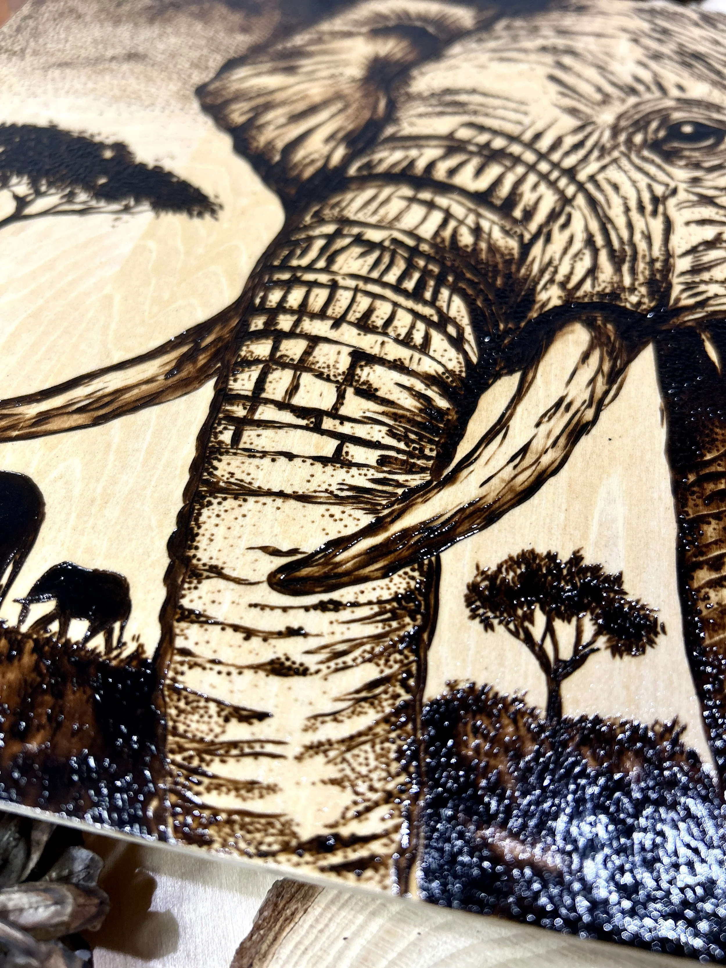 Collection of wood-burned pyrography artworks showcasing handcrafted fantasy art in unique, artisan, one-of-a-kind designs and decor, featuring detailed Savanna Reverie elephant scenes on natural wood