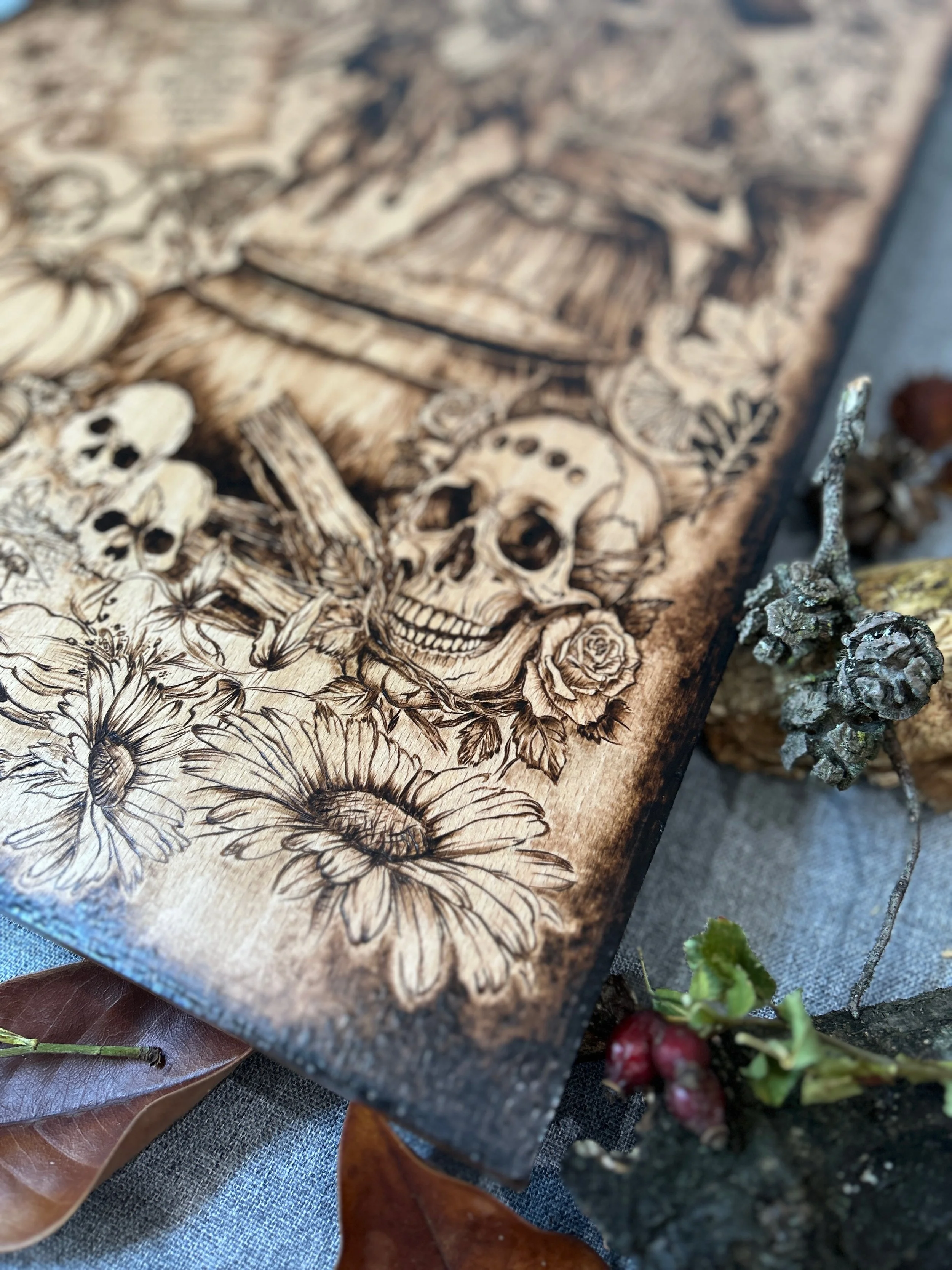 Angled close-up of The Darkest Wishes pyrography, highlighting intricate layering of witch, pumpkins, daisies, and wood grain integration.