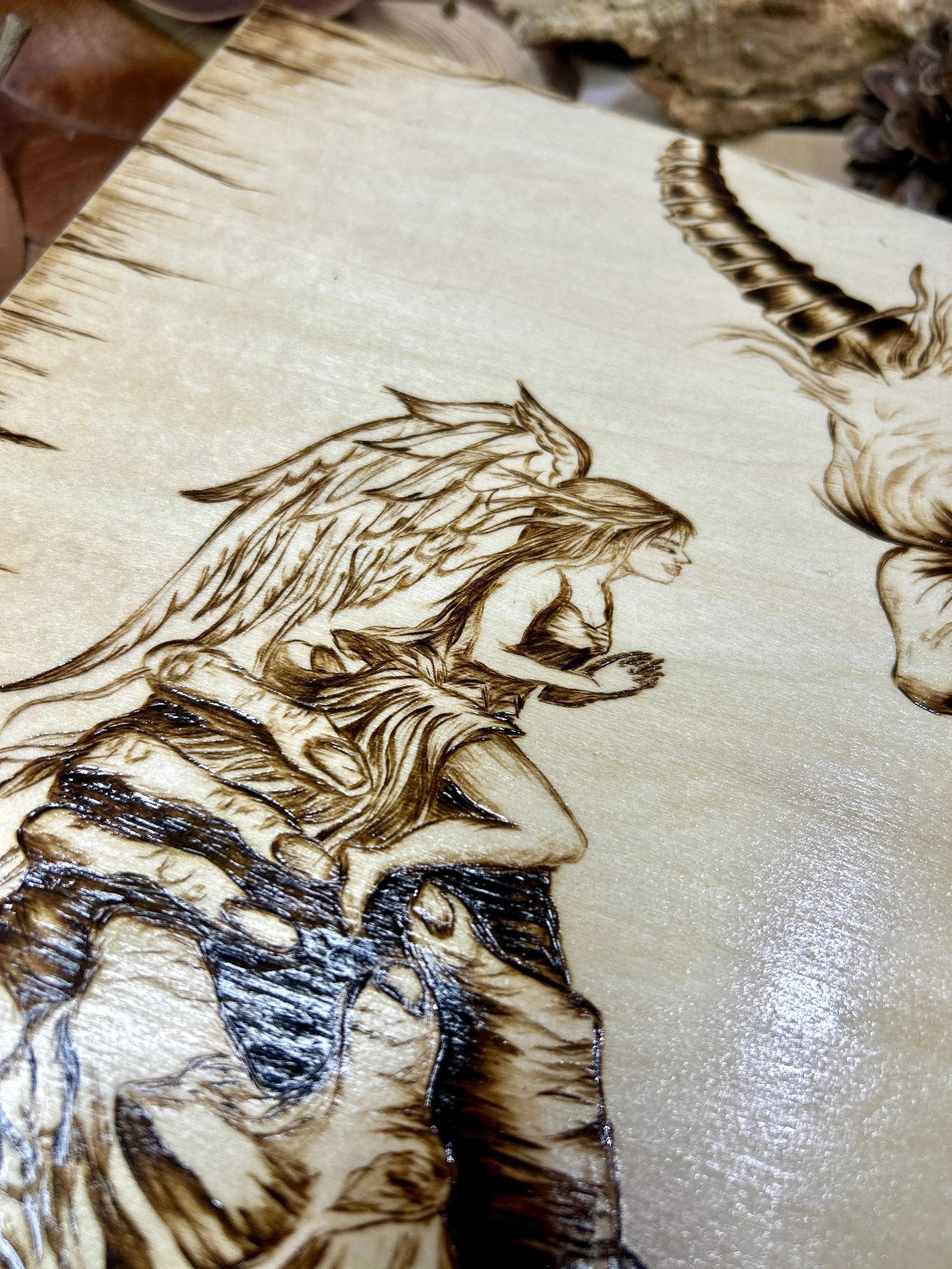 Collection of wood-burned pyrography artworks featuring angels and demons, showcasing handcrafted fantasy art in unique, artisan, one-of-a-kind designs and decor